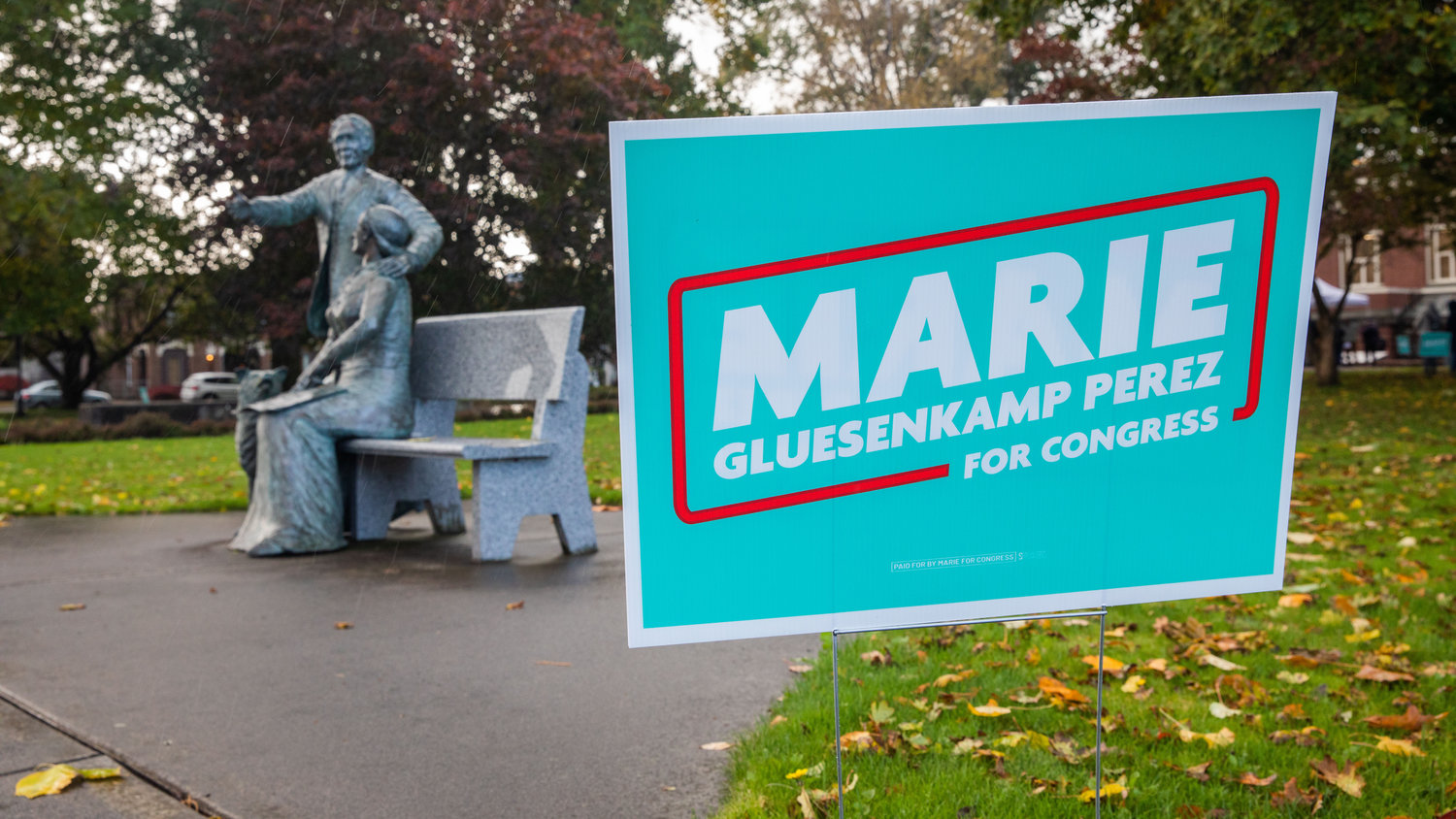 A Marie Gluesenkamp Perez campaign sign is displayed next to a statue of George and Mary Jane Washington Saturday afternoon outside the Centralia Timberland Library.