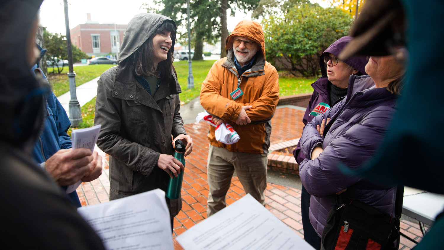 Marie Gluesenkamp Perez laughs with supporters while standing in the rain and talking about her campaign Saturday afternoon outside the Centralia Timberland Library.