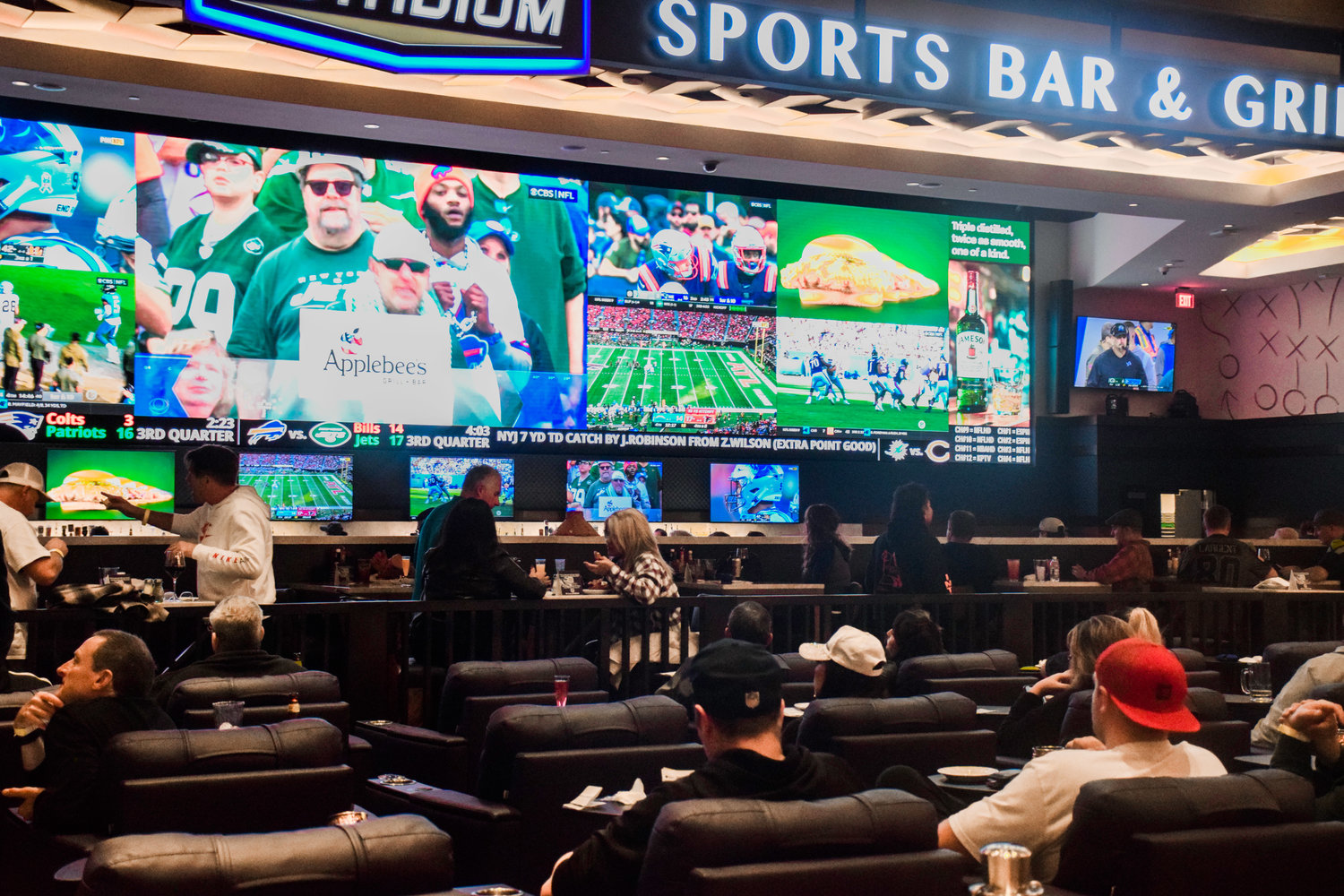 Patrons of ilani’s sports betting lounge watch games on The Stadium Bar & Grill’s video wall during a grand opening for wagering on Nov. 6.