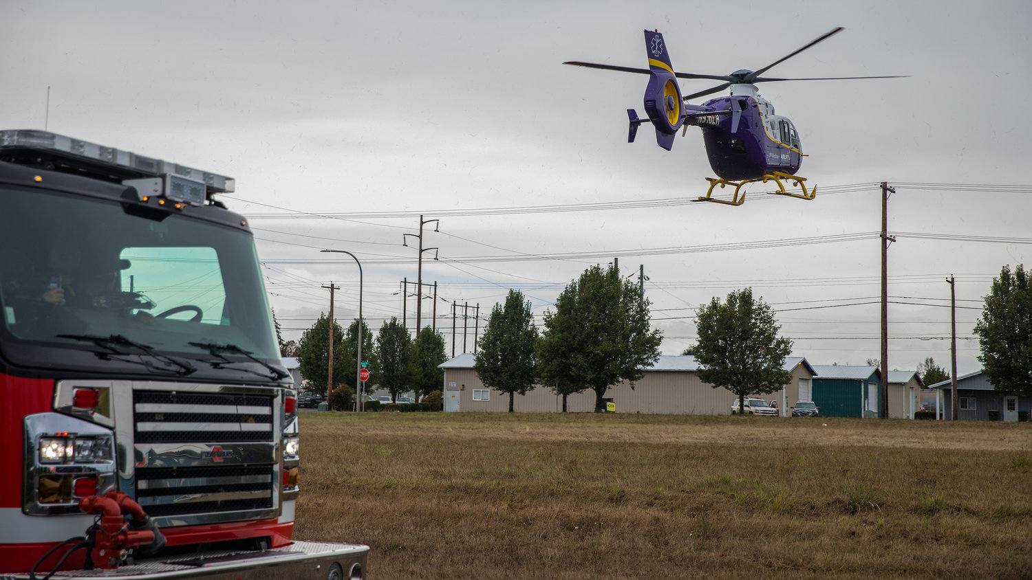 First responders watch from Steelhammer Lane in Centralia as an Airlift Northwest helicopter flies a trauma patient to Harborview Medical Center in Seattle on Sunday.