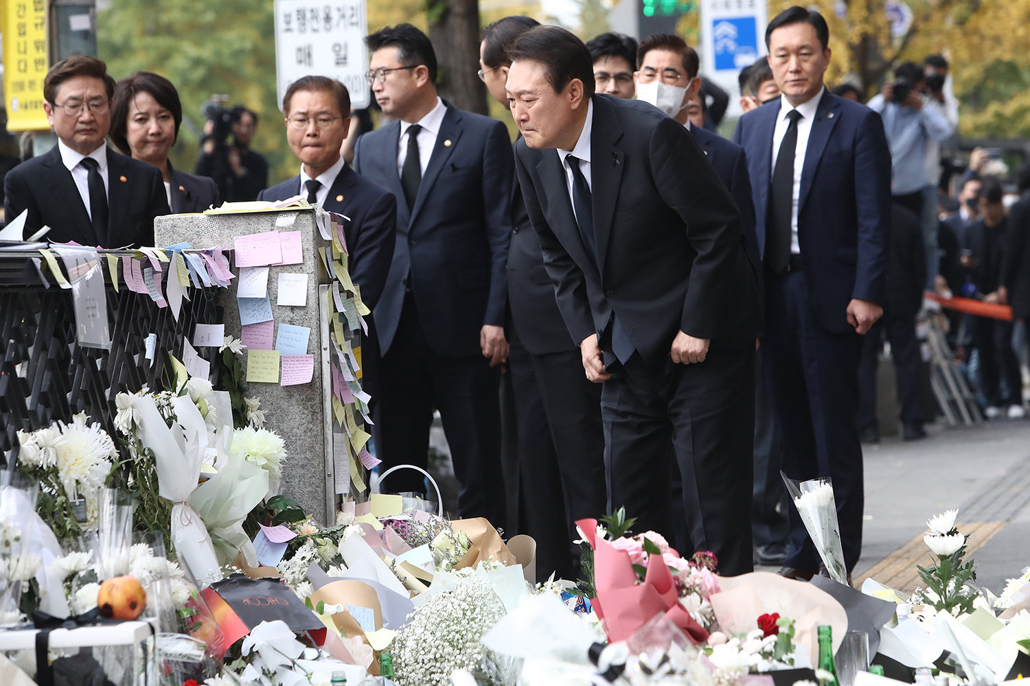 South Korean President Yoon Suk Yeol reads messages written by mouners while paying tribute to the victims of the Halloween celebration stampede, on the street near the scene on Nov. 1, 2022, in Seoul, South Korea. (Chung Sung-Jun/Getty Images/TNS)
