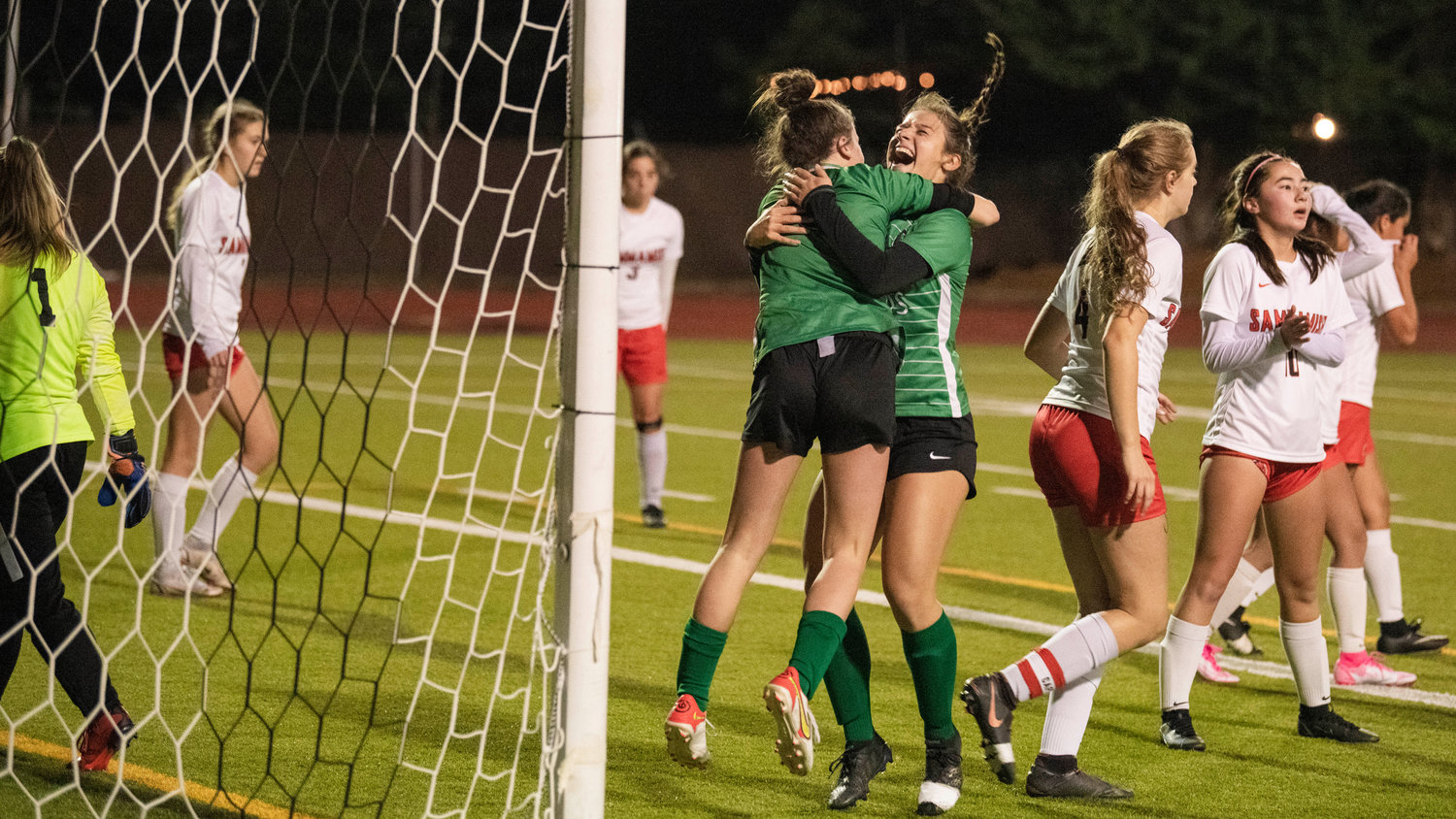 Tumwater junior Regan Brewer (9) and senior Mia Cuoio (8) celebrate a goal with an embrace Wednesday night.
