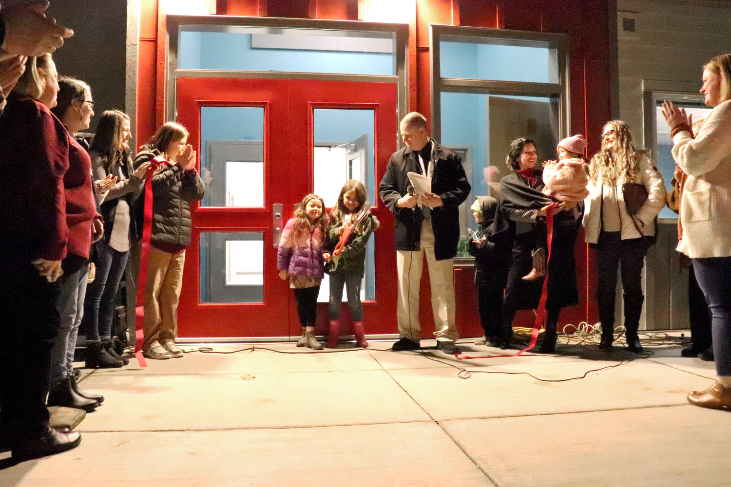 Oakville community members applaud after seven-year-olds Claire and Lexie cut the ribbon to the new Oakville Elementary School on Wednesday.