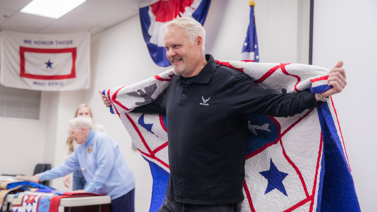 Col. Patrick Taylor smiles as he is presented with a Quilt of Valor on Veterans Day during the 25th anniversary of the Veterans Memorial Museum.