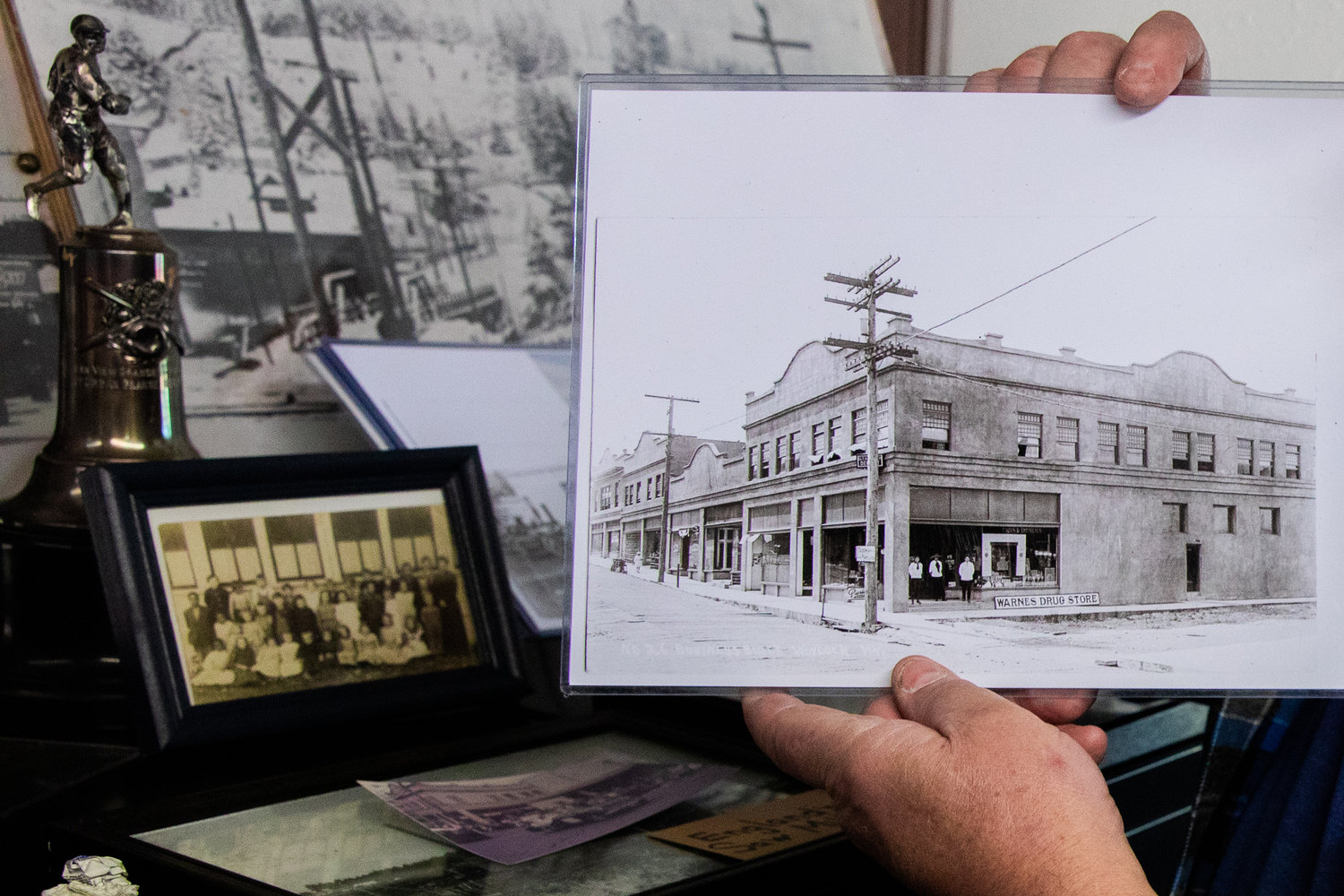 Museum President Tommy Thompson holds up a black and white photo of the Warne’s Drug Store in downtown Winlock.