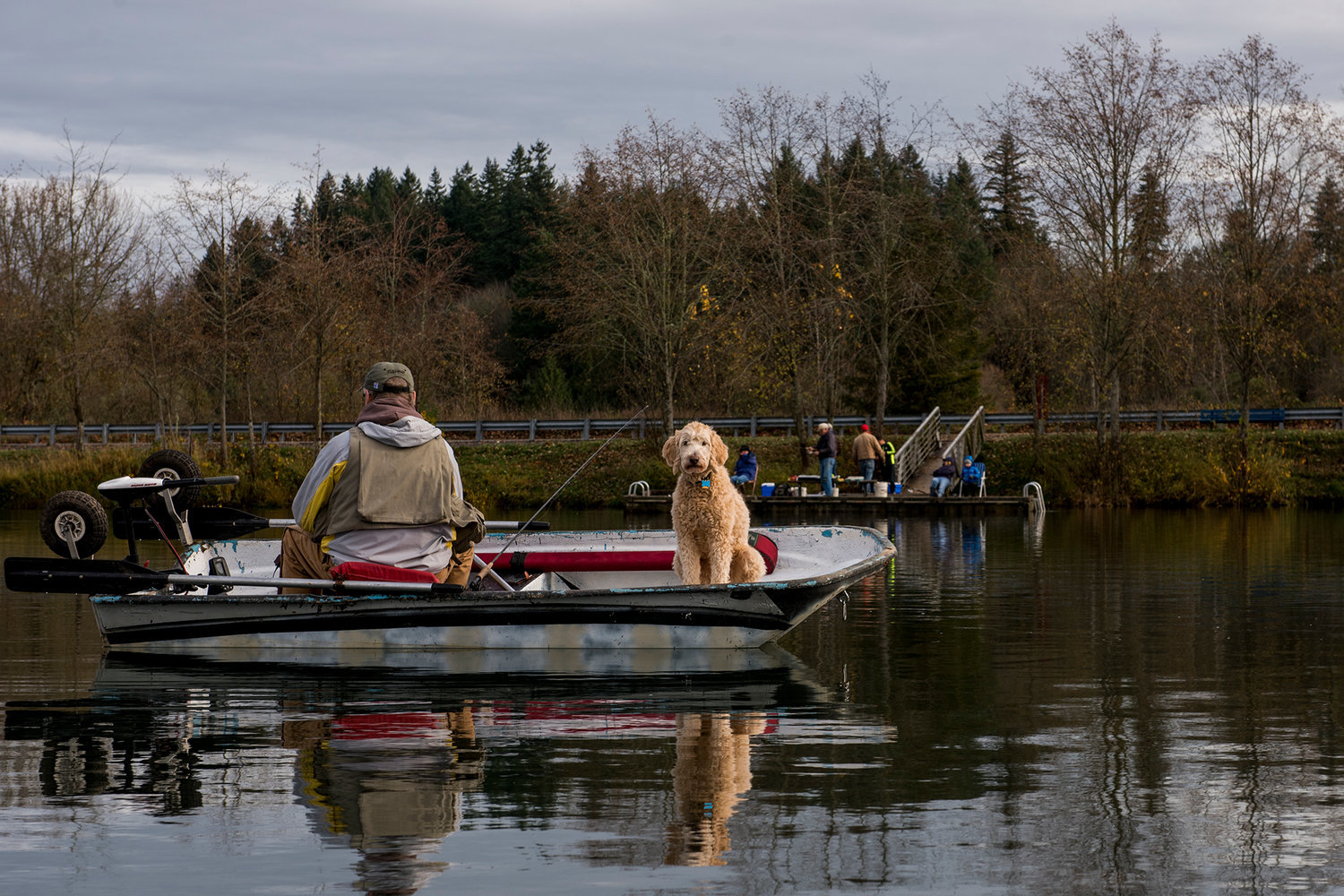 John Stotka keeps an eye on his fishing pole while his fishing partner, Penny the Dog, watches out for ducks in this 2017 Chronicle file photo.