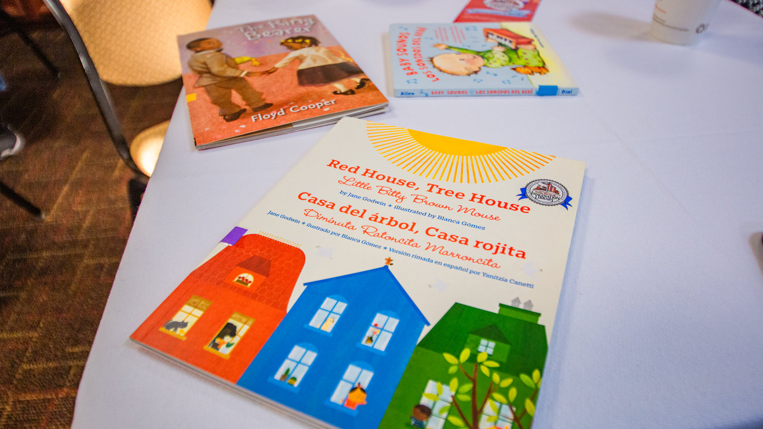 Bilingual and English children’s books that are part of the Dolly Parton Imagination Library Program sit on tables in the Holiday Inn during a Friday morning meeting of the Twin Cities Rotary.