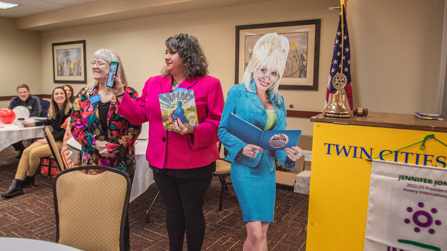 Twin Cities Rotary President Deborah Fruitman, left, and Rotarian Val Eckoff draw a name to give out a children’s book from Dolly Parton Imagination Library at the Holiday Inn in Chehalis on Friday.