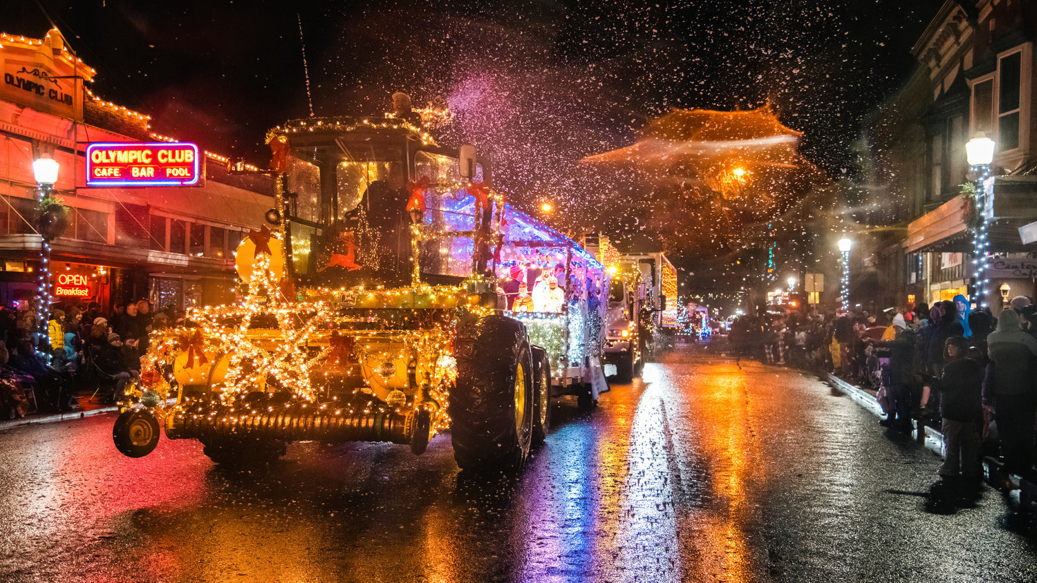 Crowds line North Tower Avenue and snow machines fill the air as floats illuminated with Christmas lights make their way through downtown Centralia during the Lighted Tractor Parade in 2021.