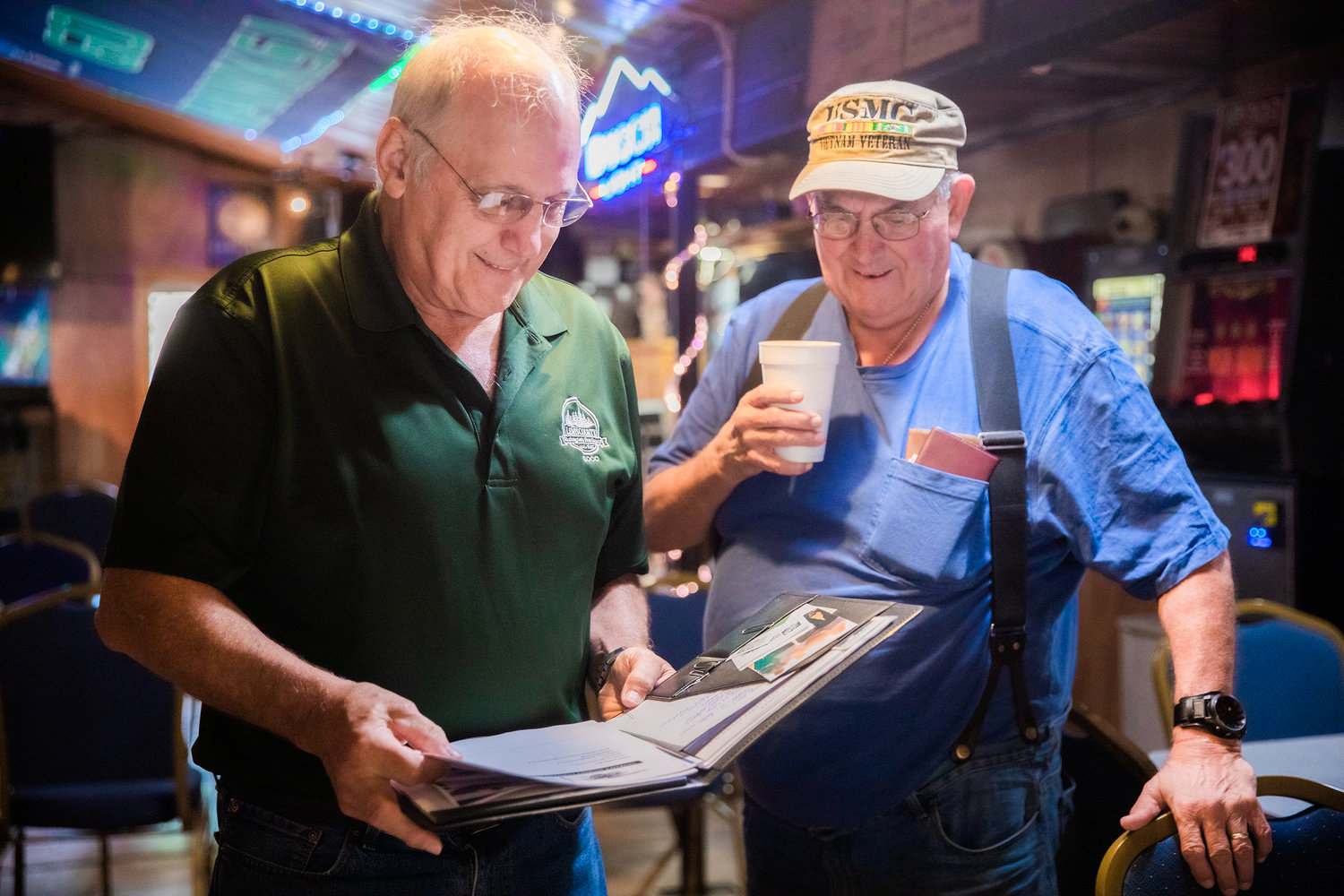Commissioner Lee Grose laughs and talks with George Schaefer, a U.S. Marine Corps veteran, last August in Randle at the Tall Timber Restaurant.