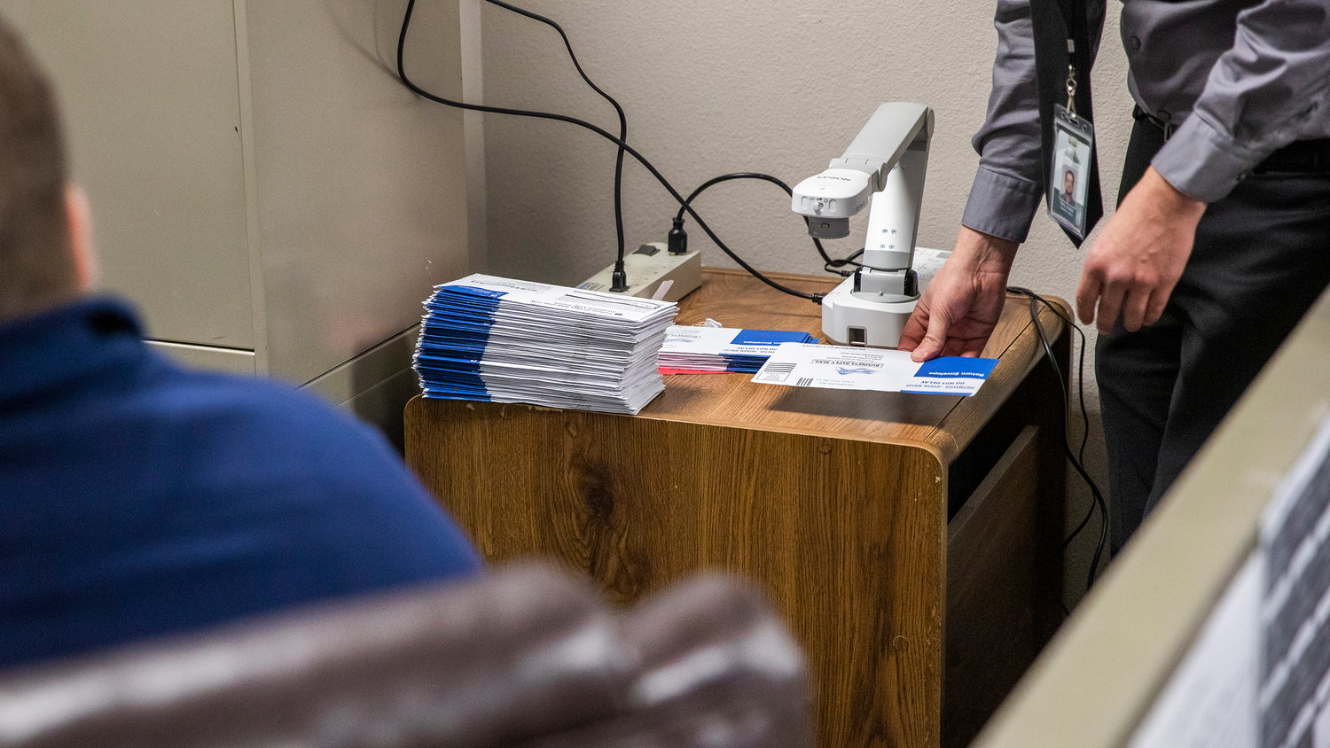 Elections Supervisor Terry Jouper reviews ballots as members of the canvasing board look for incorrect postage dates during a Wednesday morning meeting at the Lewis County Courthouse in Chehalis.
