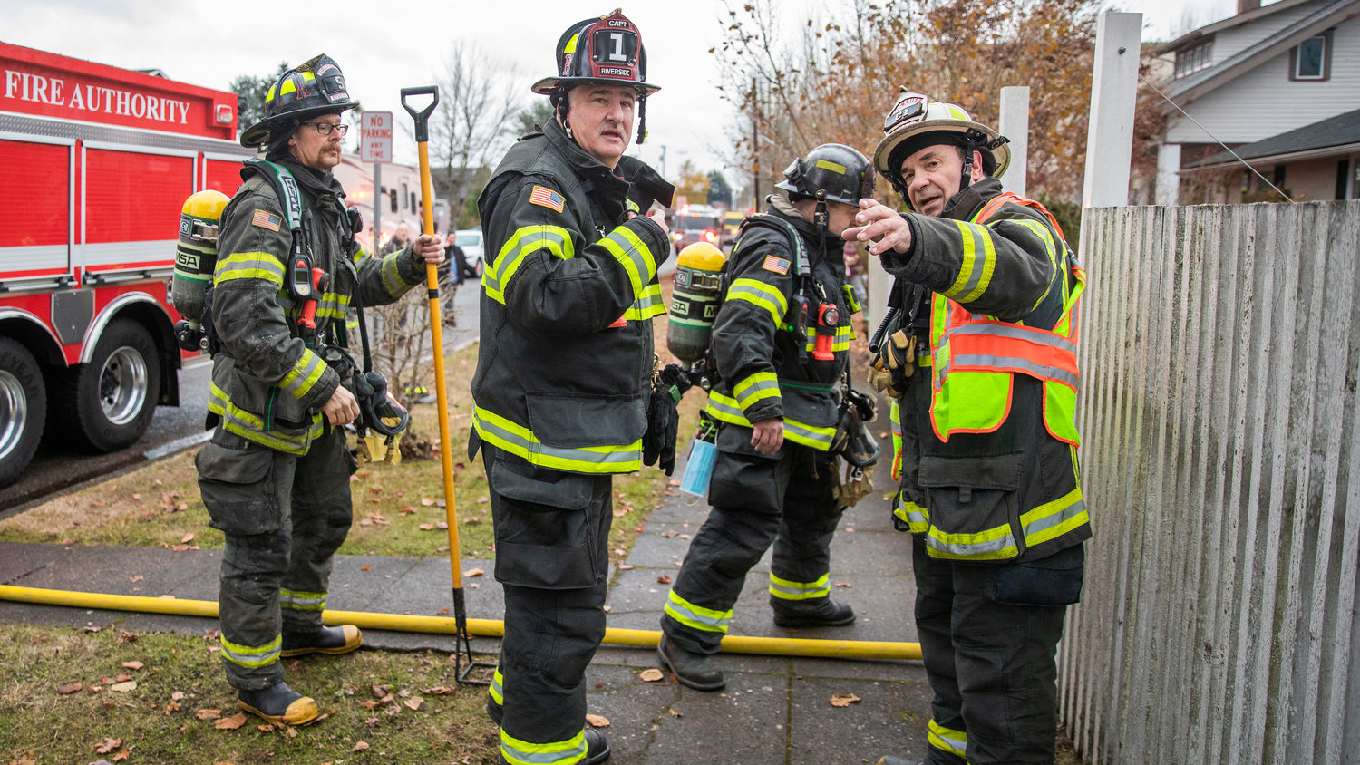 Chief Mike Kytta, of Riverside Fire Authority, far right, organizes crews responding to a residential fire in the 200 block of North Rock Street in Centralia on Friday.