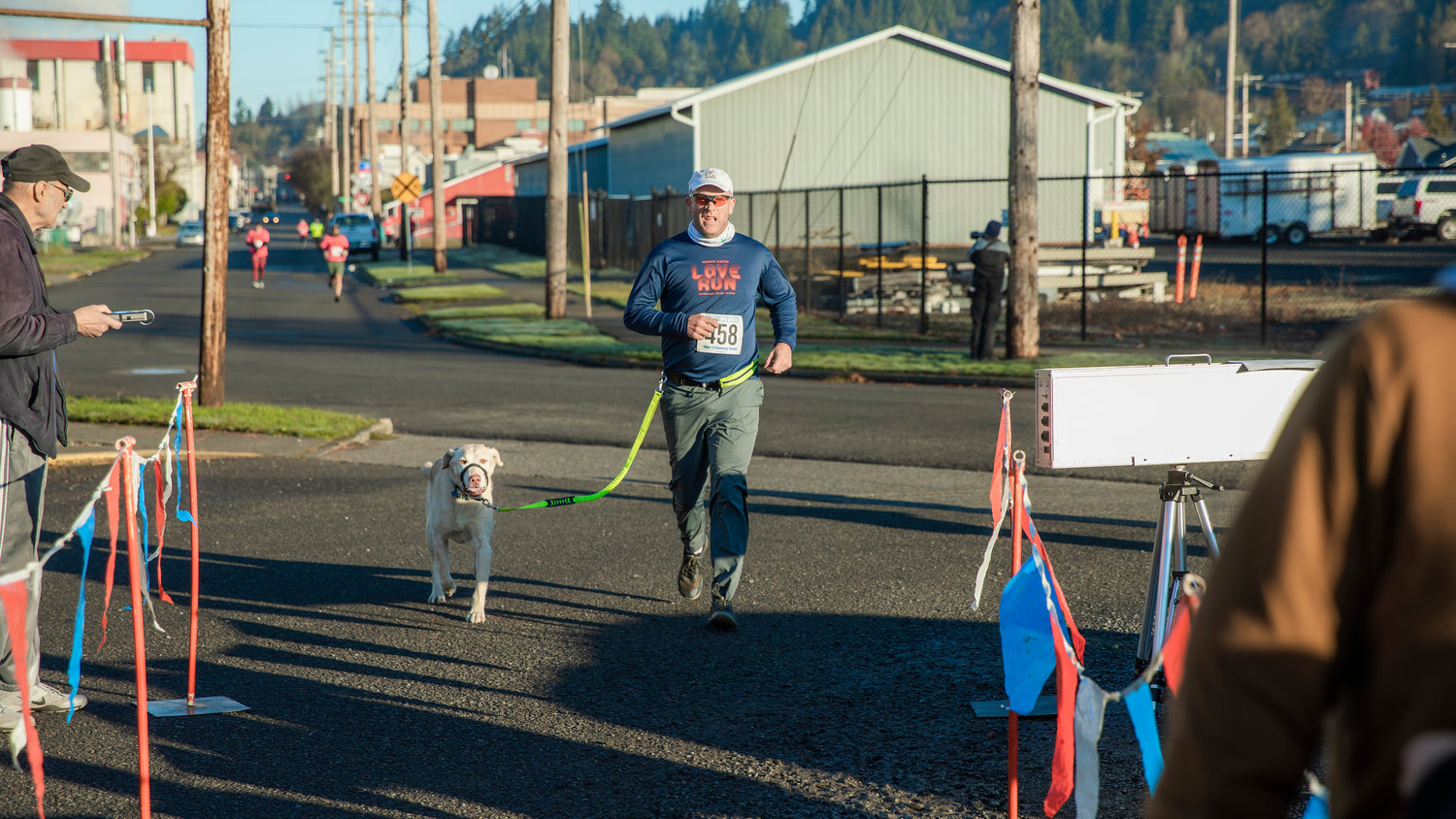 Ken Wilhelm runs alongside Odin, a yellow lab, before completing the Turkey Trot 5K Thanksgiving morning outside Thorbeckes in Chehalis.
