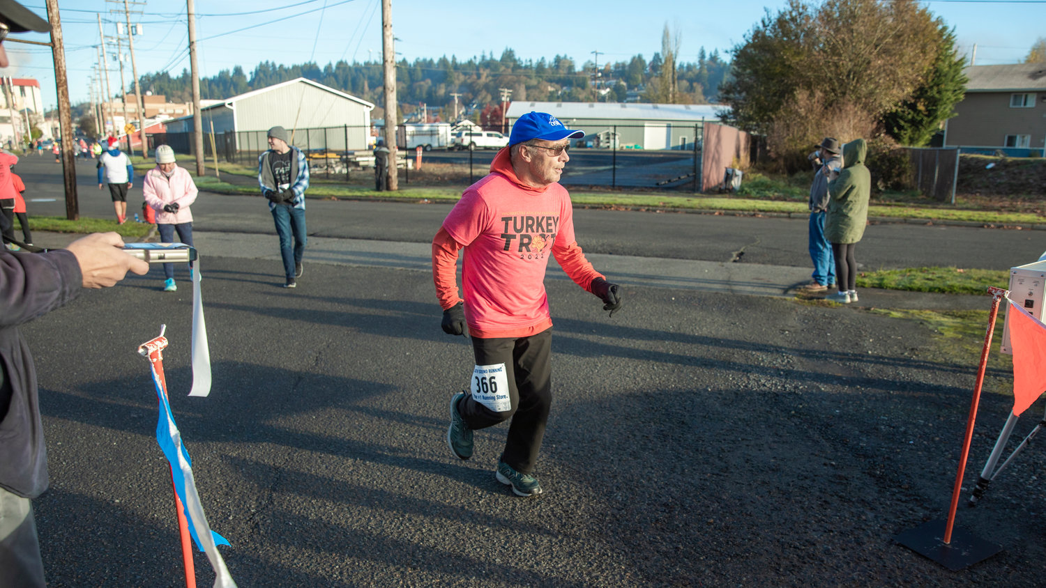 Neal Kirby, 70, runs through the finish line after completing the Turkey Trot 5K Thanksgiving morning outside Thorbeckes in Chehalis.