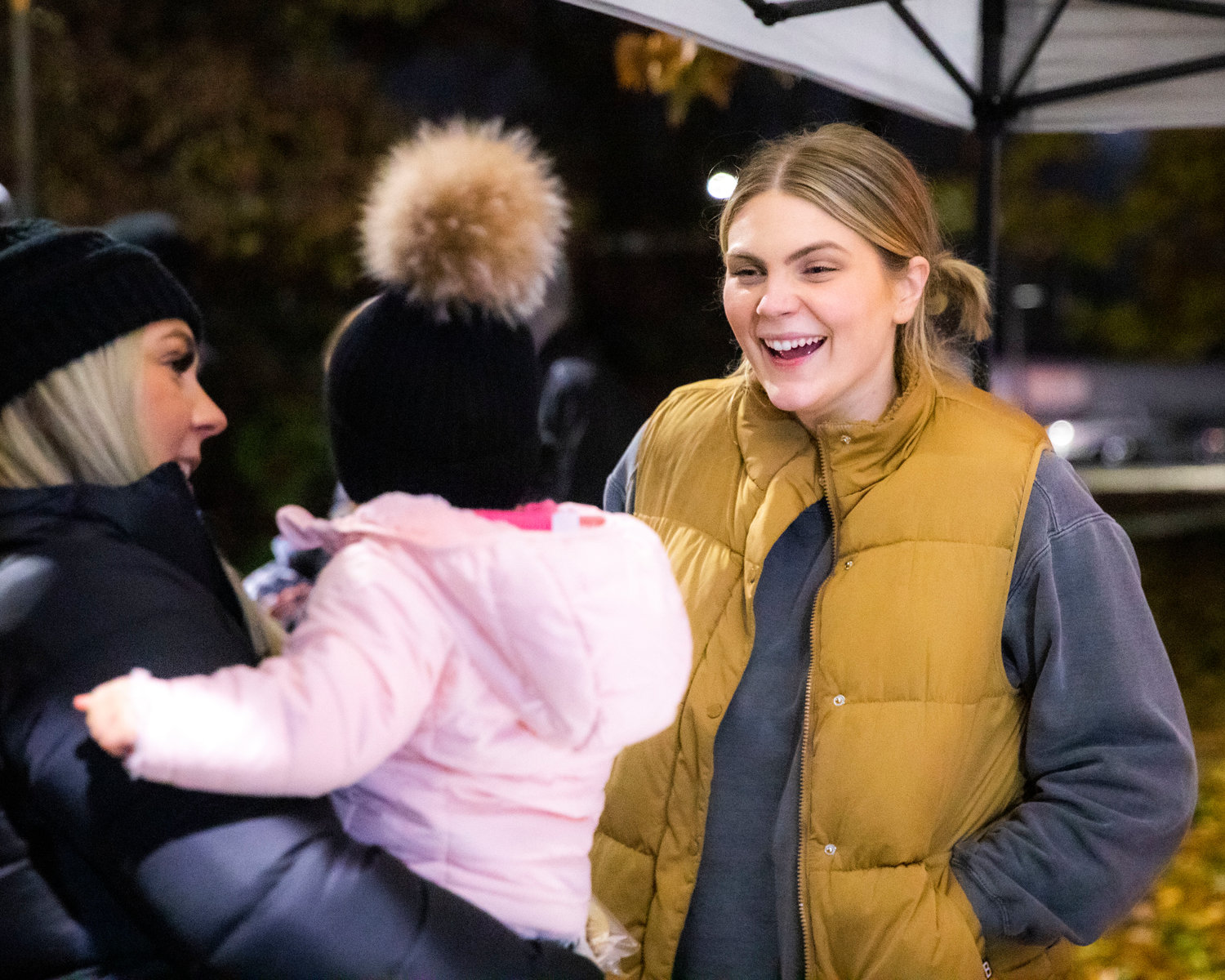 Ashlee Shirer, owner of Sweet Dough Cookie Co. smiles while greeting visitors at George Washington Park during a Christmas Tree Lighting celebration.