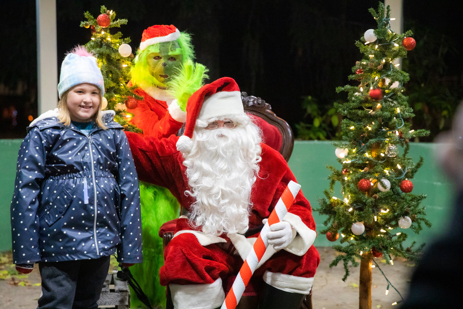 Santa and the Grinch pose for photos with kids at George Washington Park Friday night during a Christmas Tree Lighting celebration.