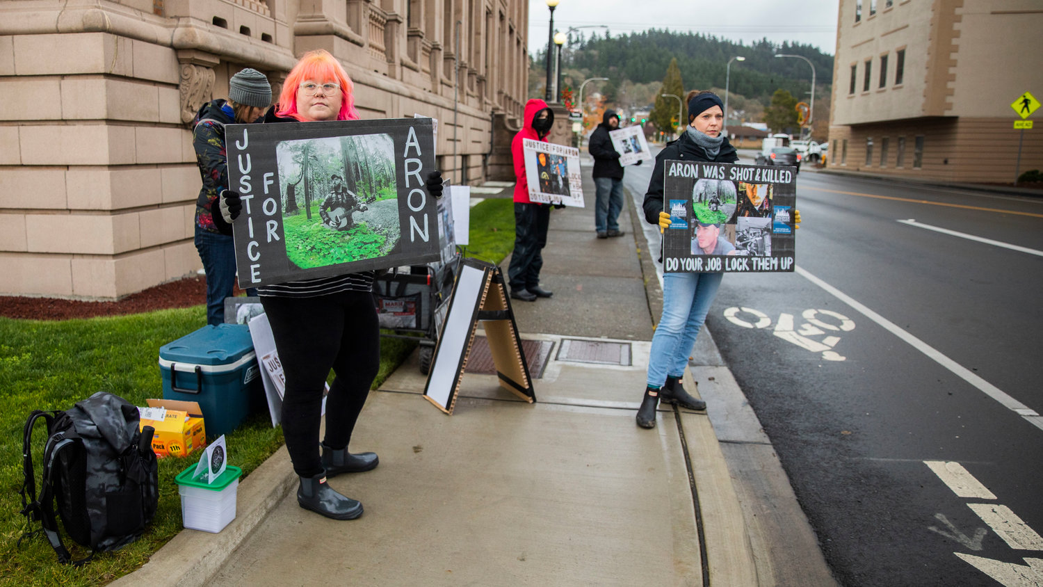 Sarah Matson and Erin Buck, of Portland, stand outside the Lewis County Courthouse while demanding justice in the death of Aron Christensen and his dog Buzzo Sunday afternoon in Chehalis.