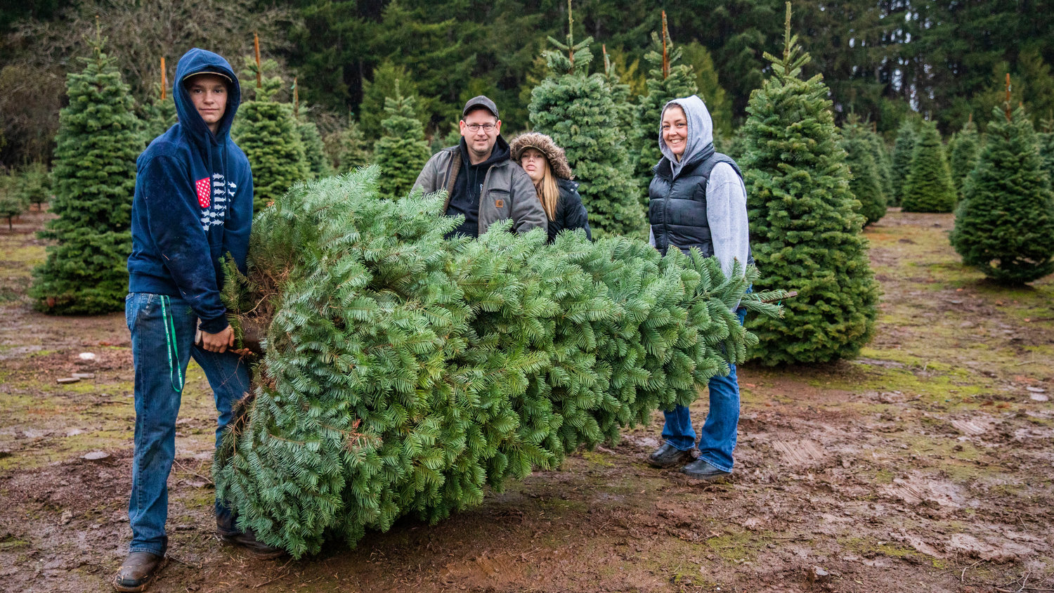 The Haag family of Chehalis poses for a photo after chopping down a tree at the Mistletoe Tree Farm on Friday.