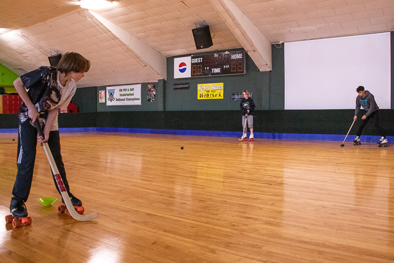 members of the Centralia Sharks rollerhockey club work on passing drills at the Centralia Rollerdome.
