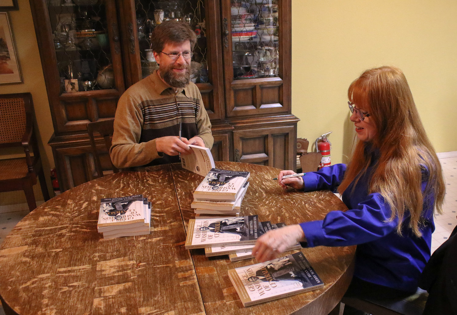 Authors Brian Mittge and Kery Serl sign copies of the newly printed second edition of their biography, George Washington of Centralia, before they drop them off at local book stores.