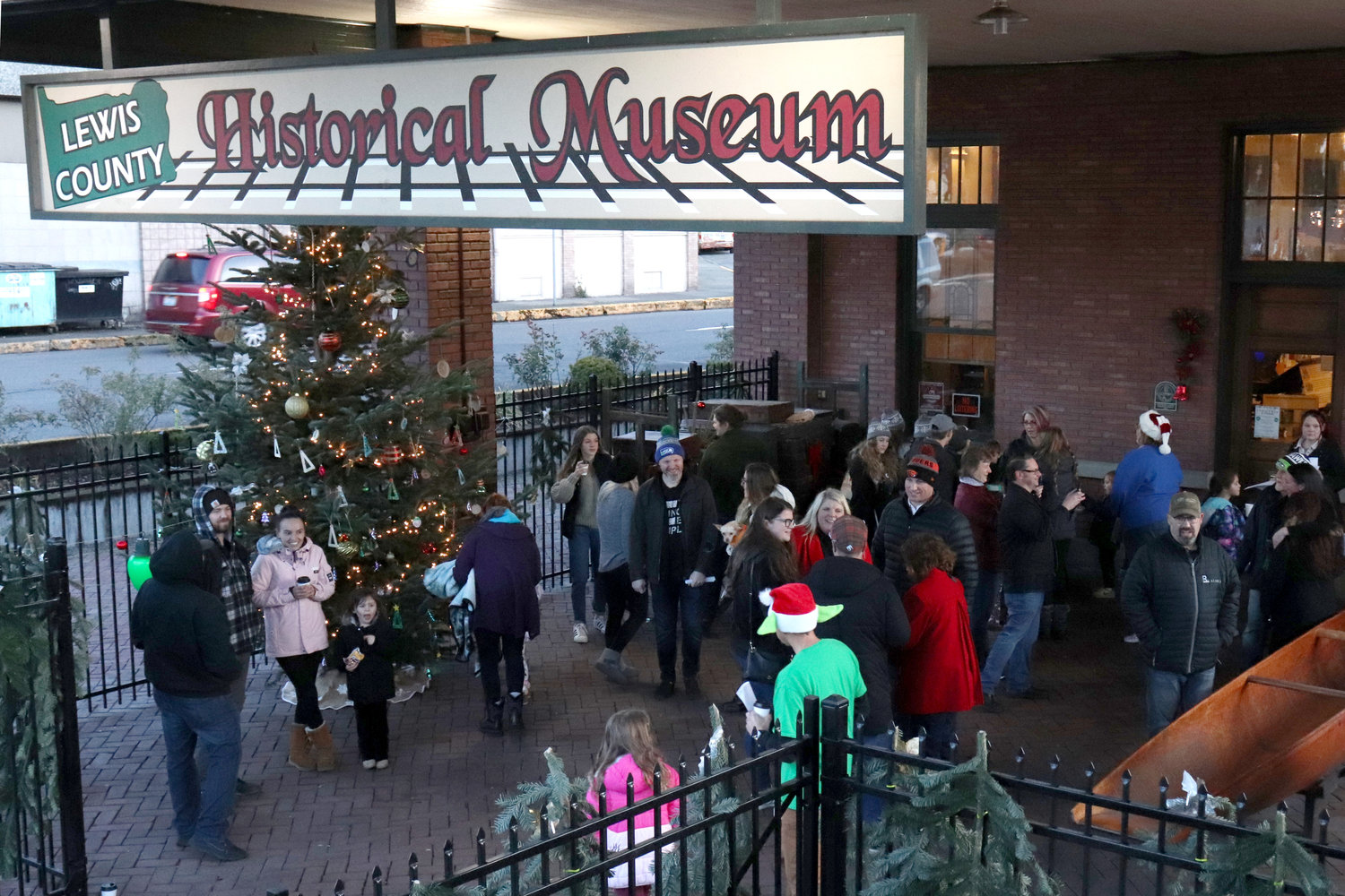 People sing carols around the City of Chehalis’ Christmas tree outside of the Lewis County Historical Museum on Saturday.