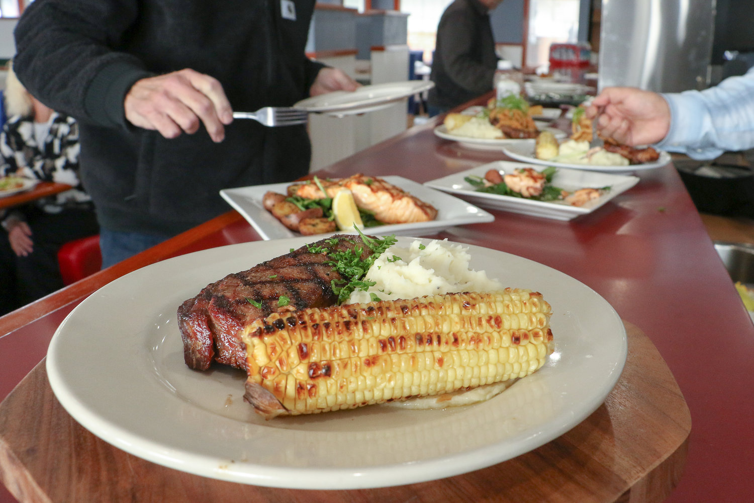 Prepared by Chef Eyner "Rene" Cardona, a dry-aged New York strip steak sits next to fluffy, house-made mashed potatoes and grilled corn-on-the-cob at Ocean Prime's menu sampling Monday morning.