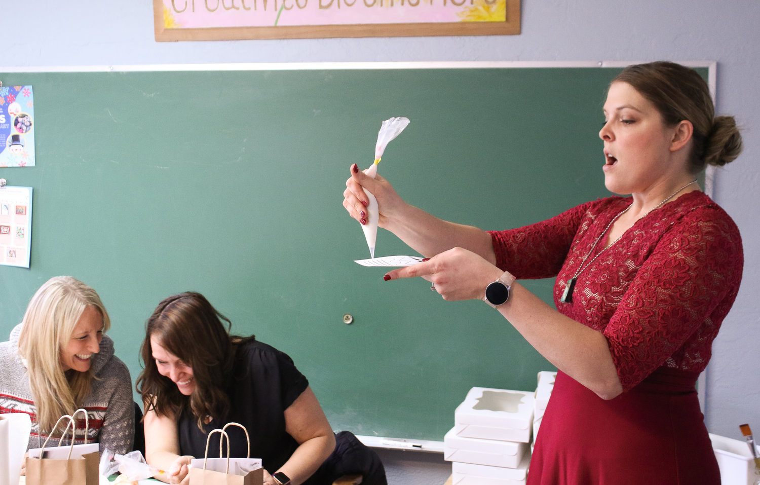 Instructor Anna Martin, owner of Anna's Bakery, demostrates proper pipping bag techniques when decorating sugar cookies with royal icing during a class she hosted at the Dandelion Creative Space on Sunday morning.