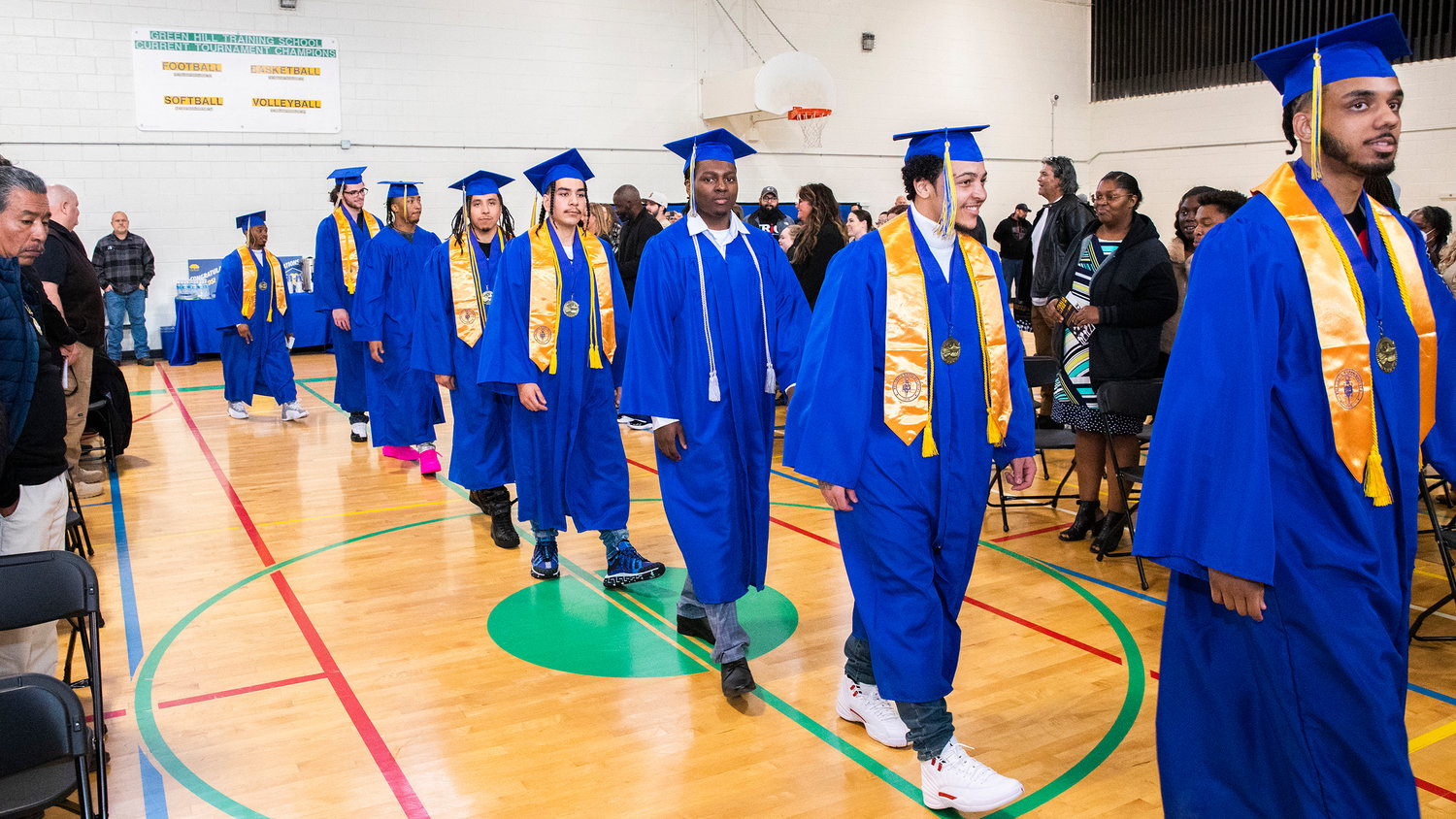 Centralia College graduates smile and walk while sporting caps and gowns during a ceremony held at the Green Hill School on Wednesday in Chehalis.