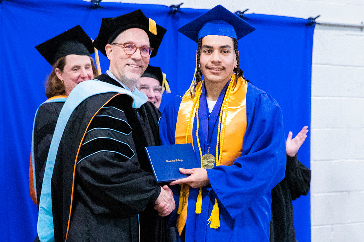 Guillermo Padilla smiles for a photo with his diploma alongside Centralia College President Dr. Bob Morhbacher during a graduation ceremony held at the Green Hill School on Wednesday in Chehalis.