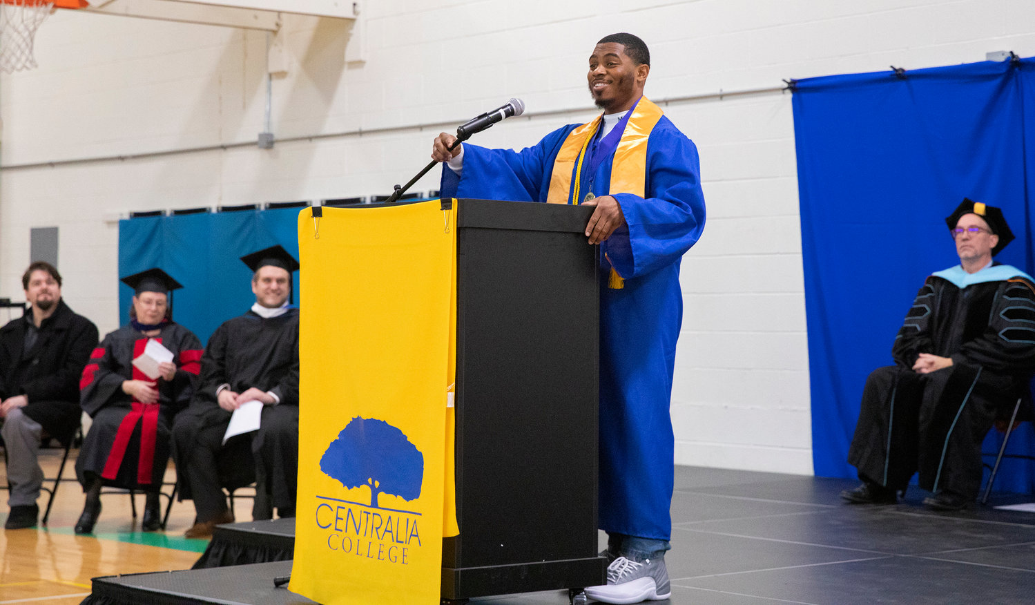 Anthony Smith smiles and makes a speech on stage during a graduation ceremony for Centralia College graduates held at the Green Hill School on Wednesday in Chehalis.
