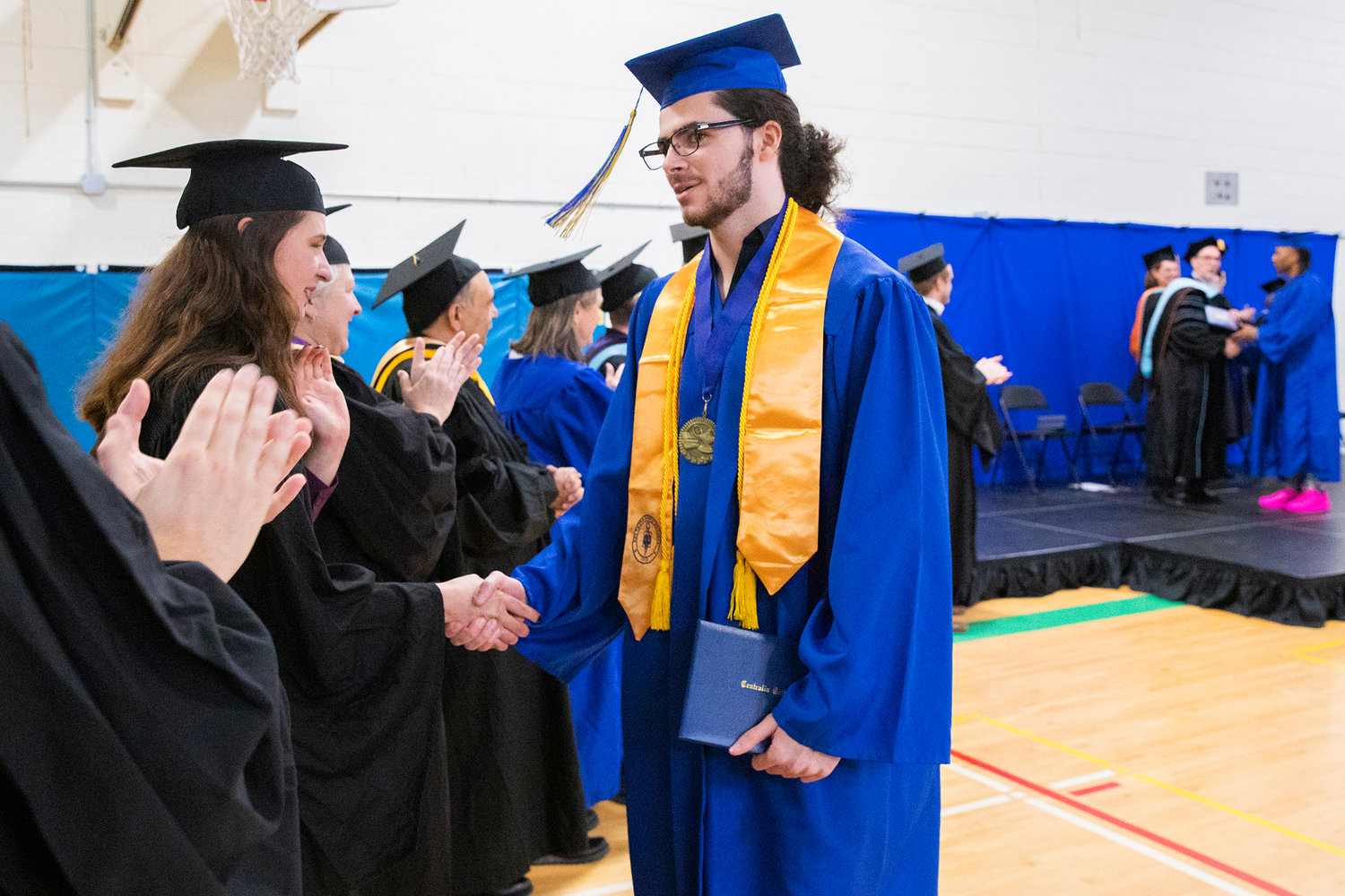 Caya Lenay shakes hands after receiving his diploma during a graduation ceremony for Centralia College graduates held at the Green Hill School on Wednesday in Chehalis.