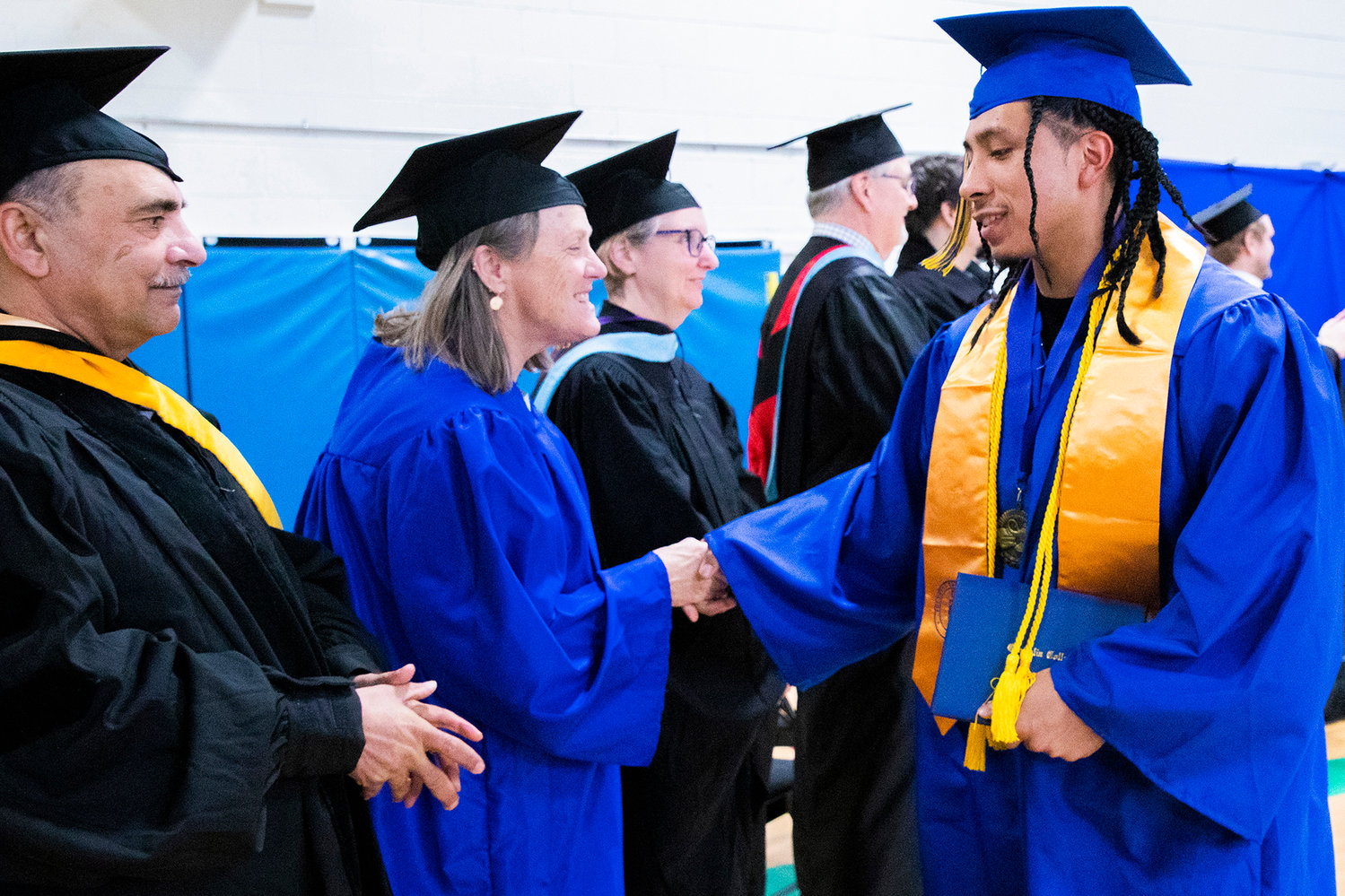 Edgar Calixto smiles and shakes hands after receiving his diploma during a graduation ceremony for Centralia College graduates held at the Green Hill School on Wednesday in Chehalis.