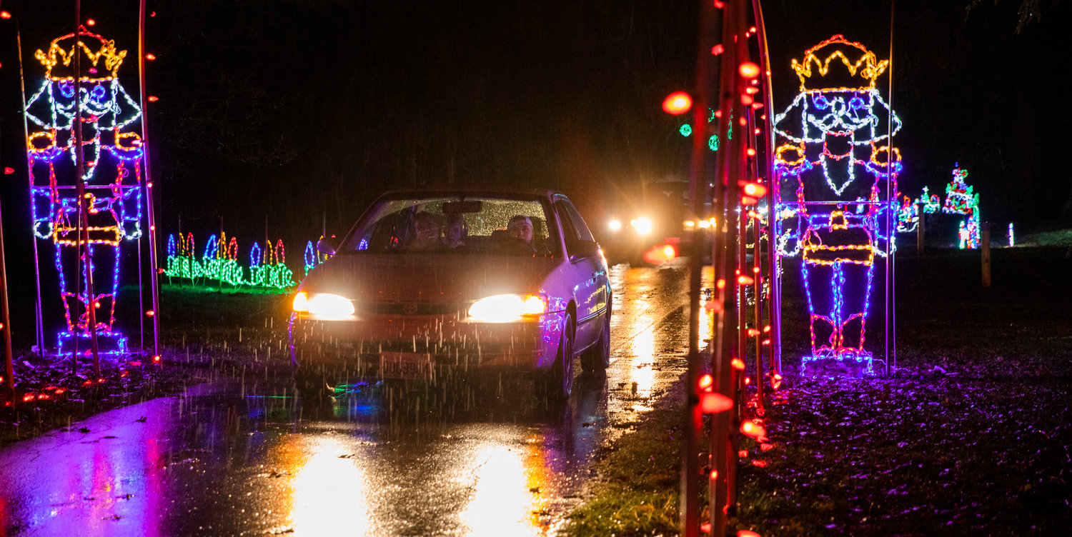 Cars drive through a tunnel of Christmas lights illuminating Borst Park Thursday night in Centralia.