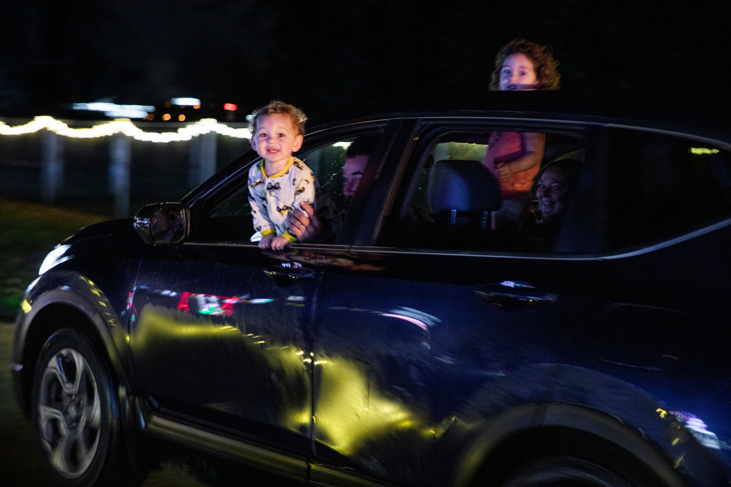 Kids watch Christmas lights through openings in windows as their family drives through Borst Park Thursday night in Centralia.