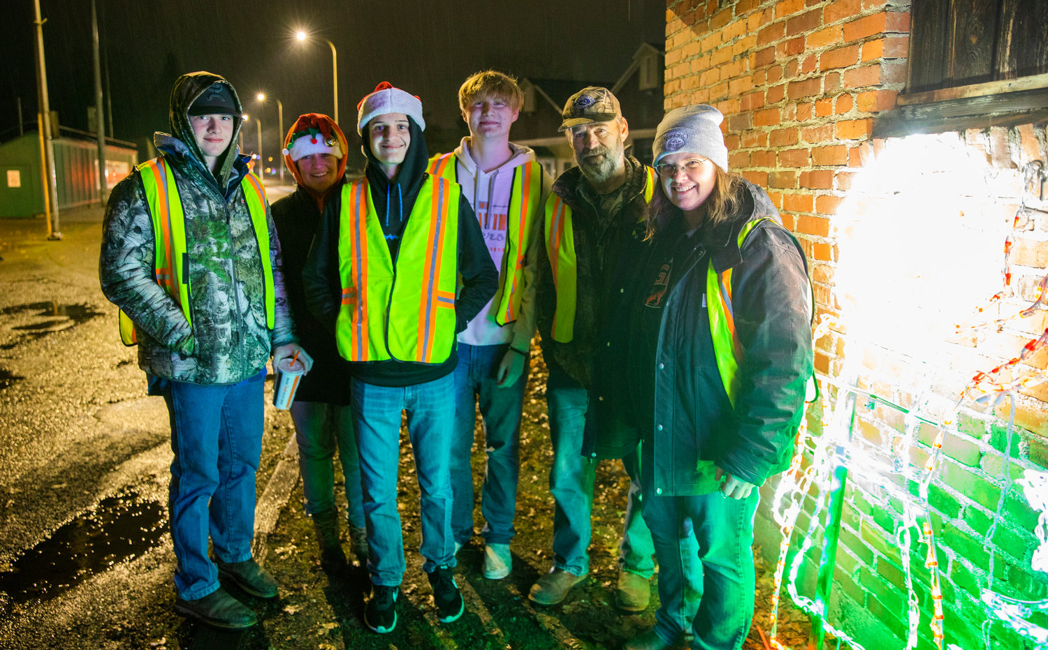 Volunteers smile for a photo at the entrance of the Borst Park Christmas lights display Thursday night in Centralia.