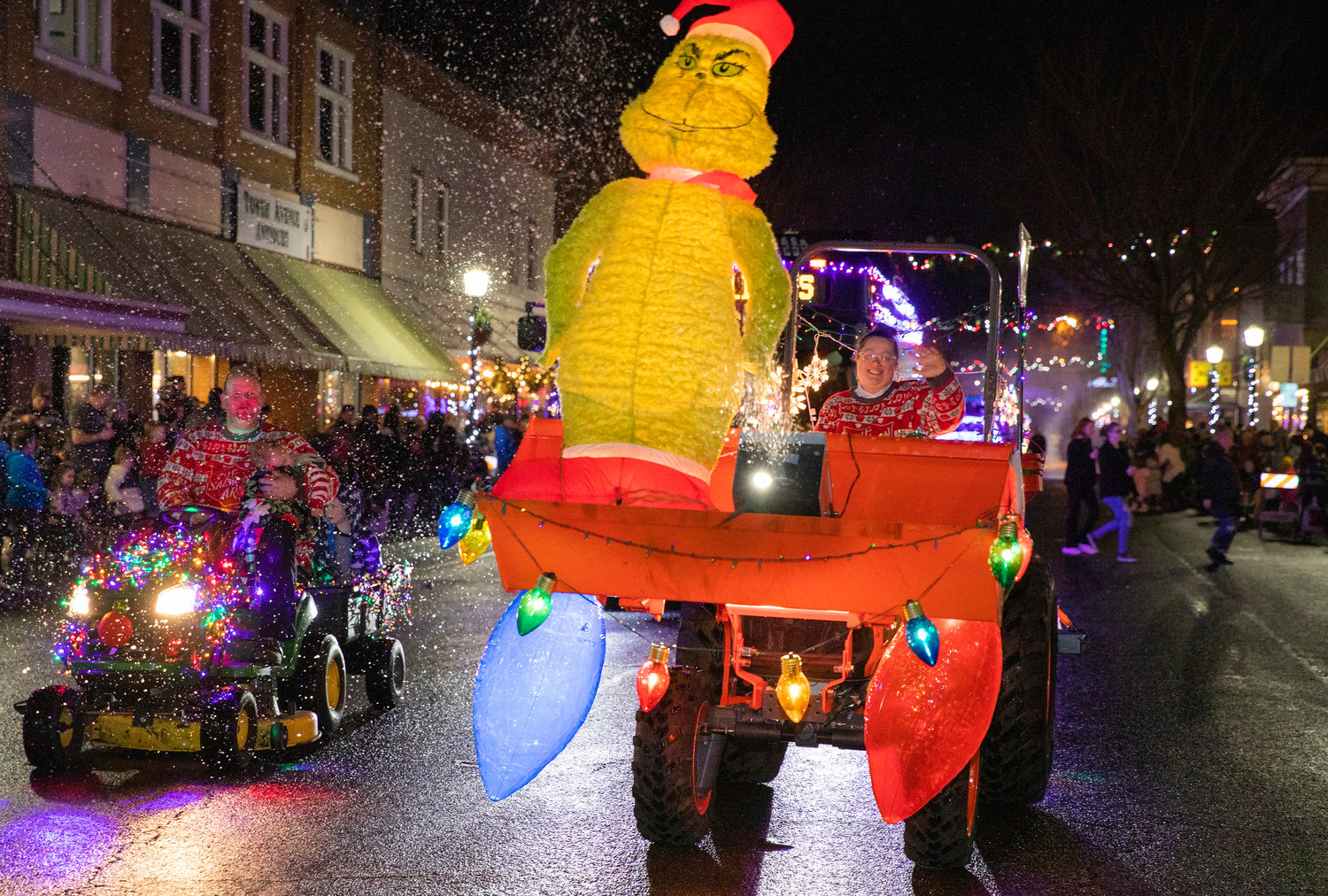 Gin and Steven Pack, with The Salvation Army, ride and wave on during the Lighted Tractor Parade Saturday night in downtown Centralia.