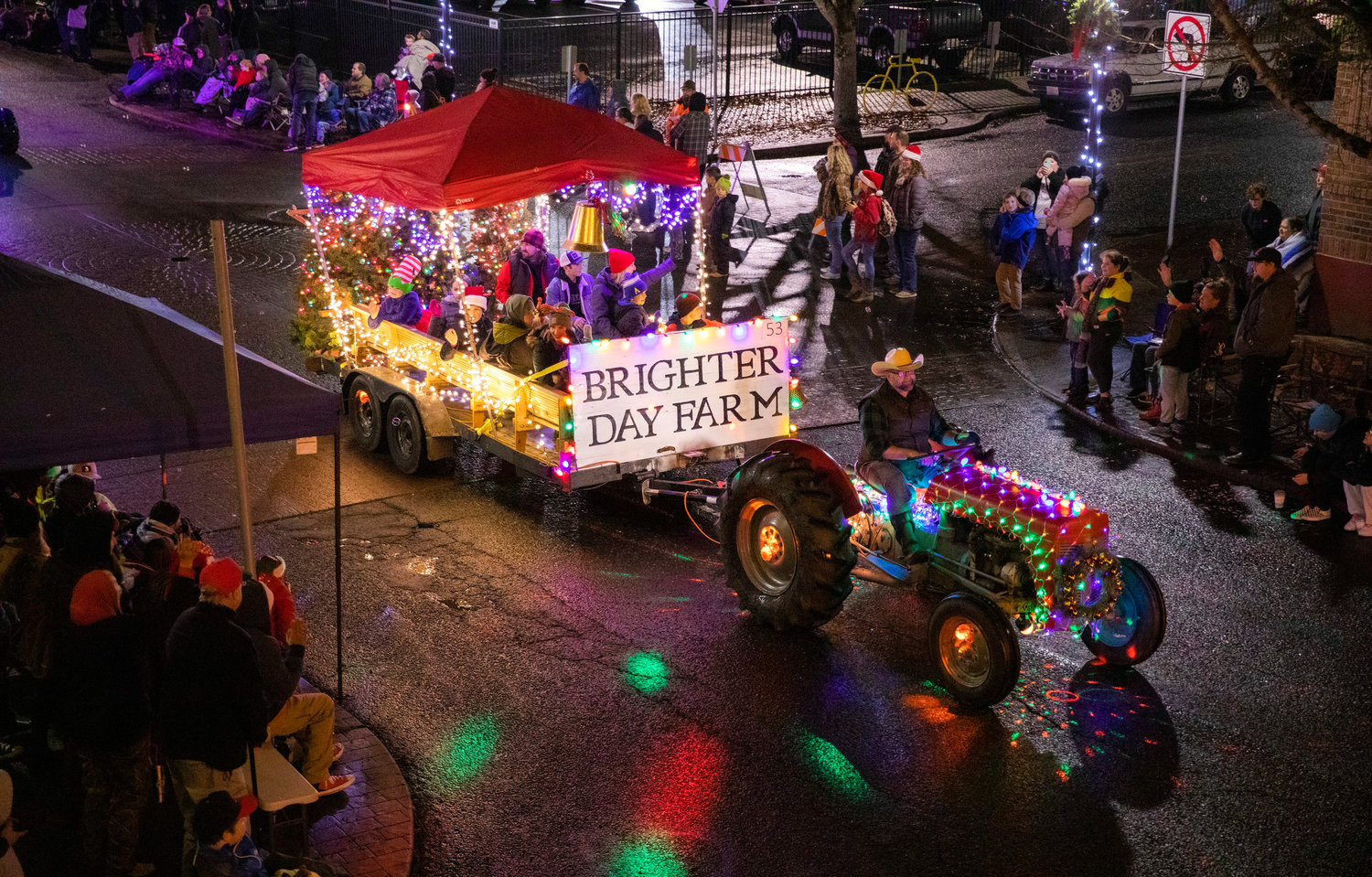Paradegoers wave and record The Brighter Day Farm float as it rolls through downtown Centralia Saturday night during the Lighted Tractor Parade.