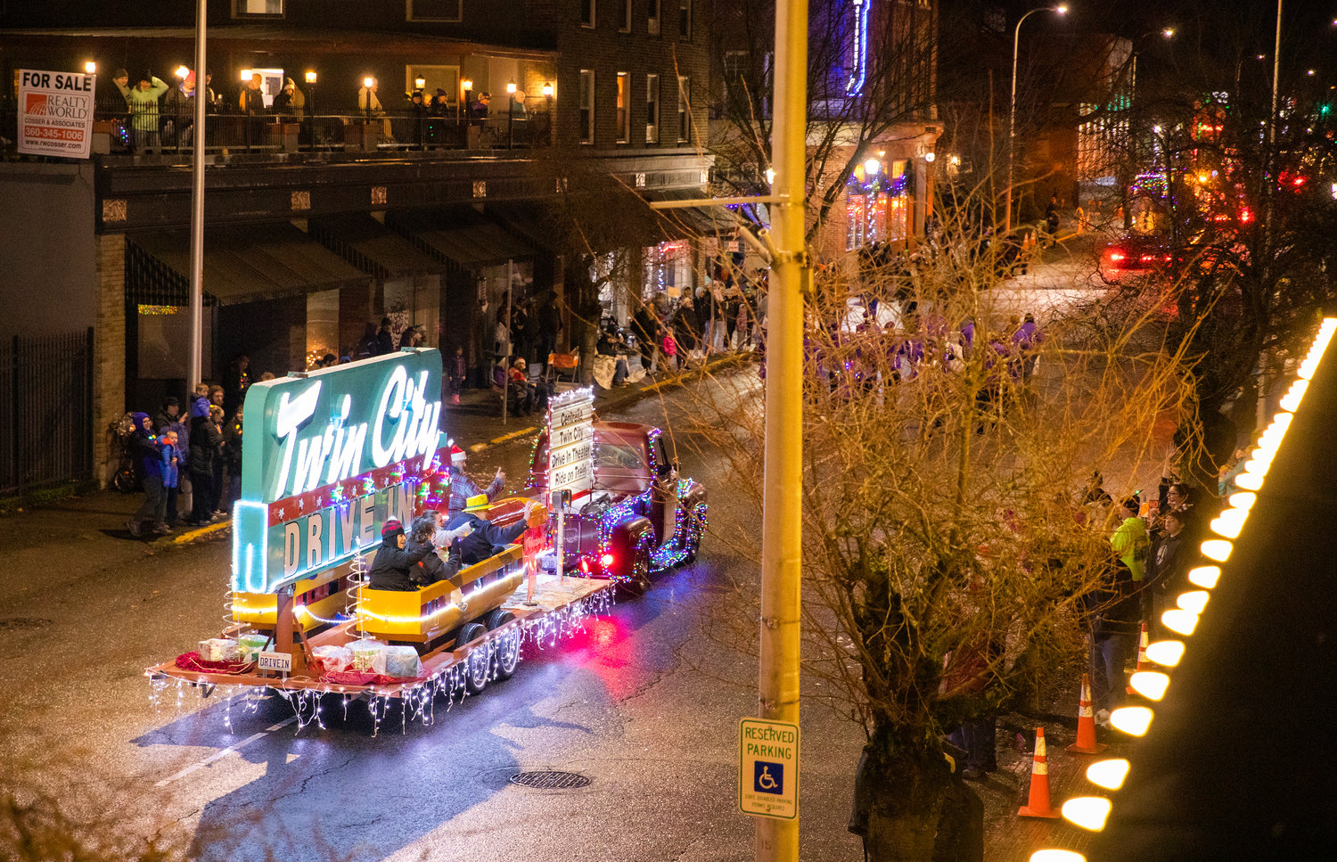 The Twin City Drive-In Theater ride-on train rolls through downtown Centralia on a float during the Lighted Tractor Parade.