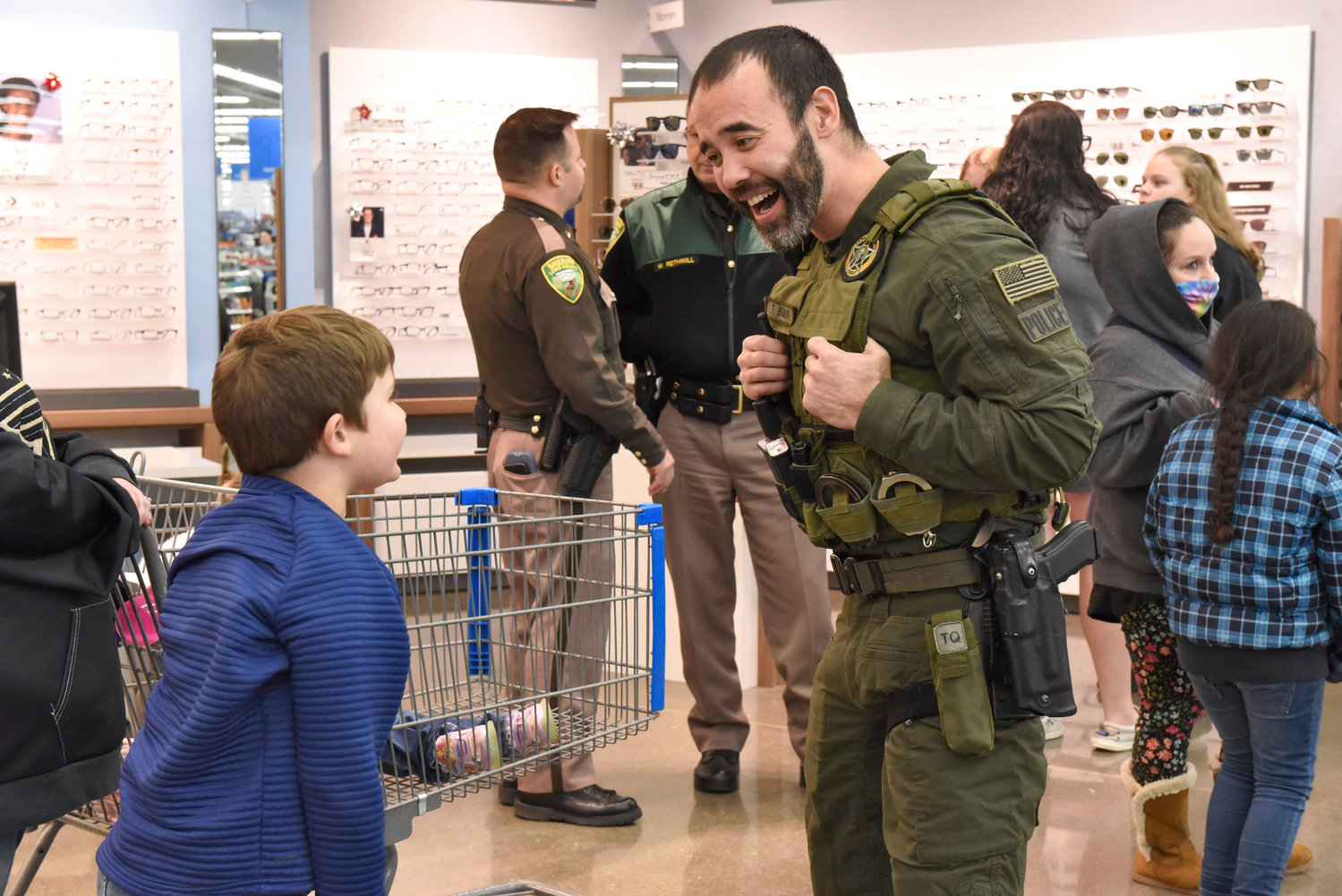 A Lewis County Sheriff’s Office deputy talks with kids participating in Shop With a Cop at Chehalis Walmart on Wednesday.