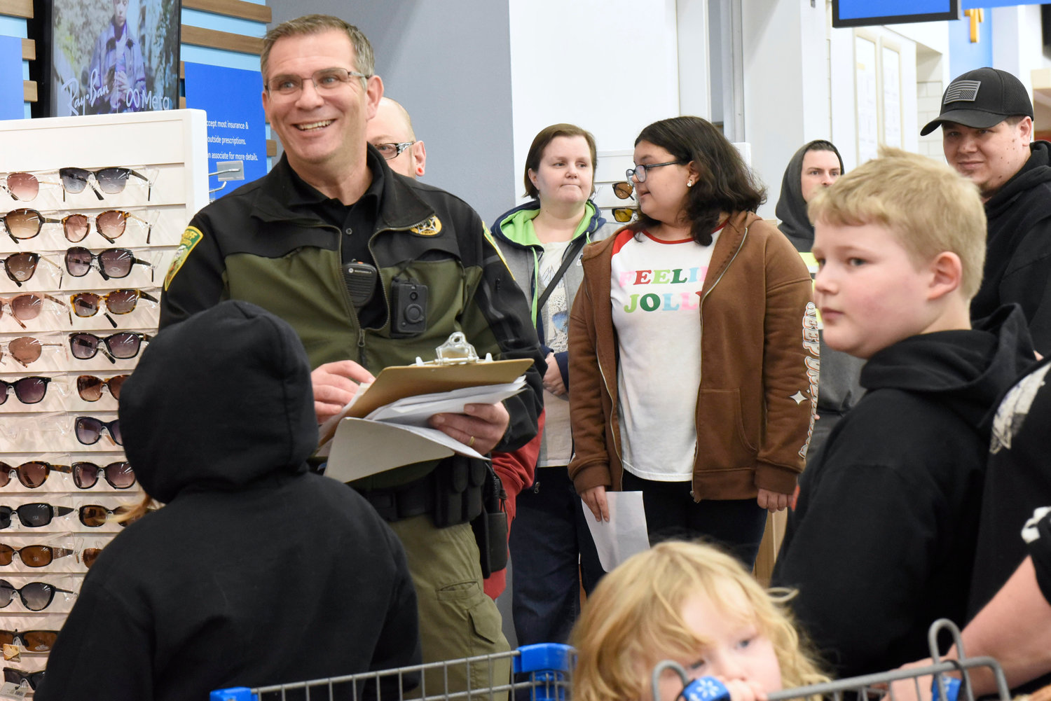 Lewis County Undersheriff Wes Rethwill smiles while interacting with kids participating in the Shop With a Cop event at Chehalis Walmart on Wednesday.