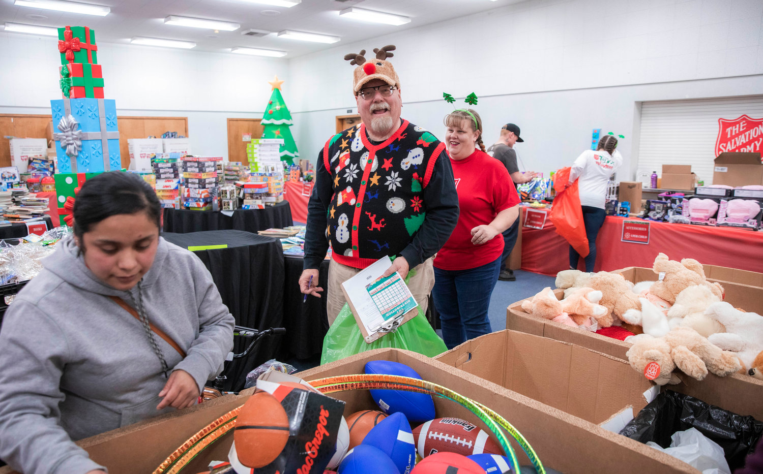 Lewis County Emergency Management Deputy Director Ross McDowell helps visitors at The Salvation Army toy giveaway Tuesday evening in Centralia.