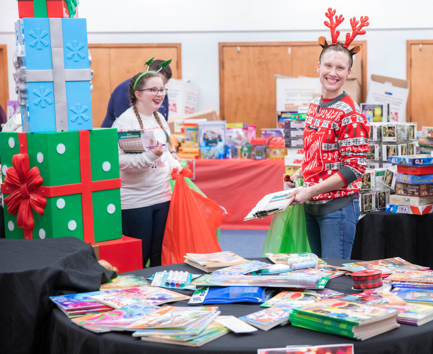 Volunteers smile while helping visitors at The Salvation Army Christmas toy giveaway Tuesday evening in Centralia.