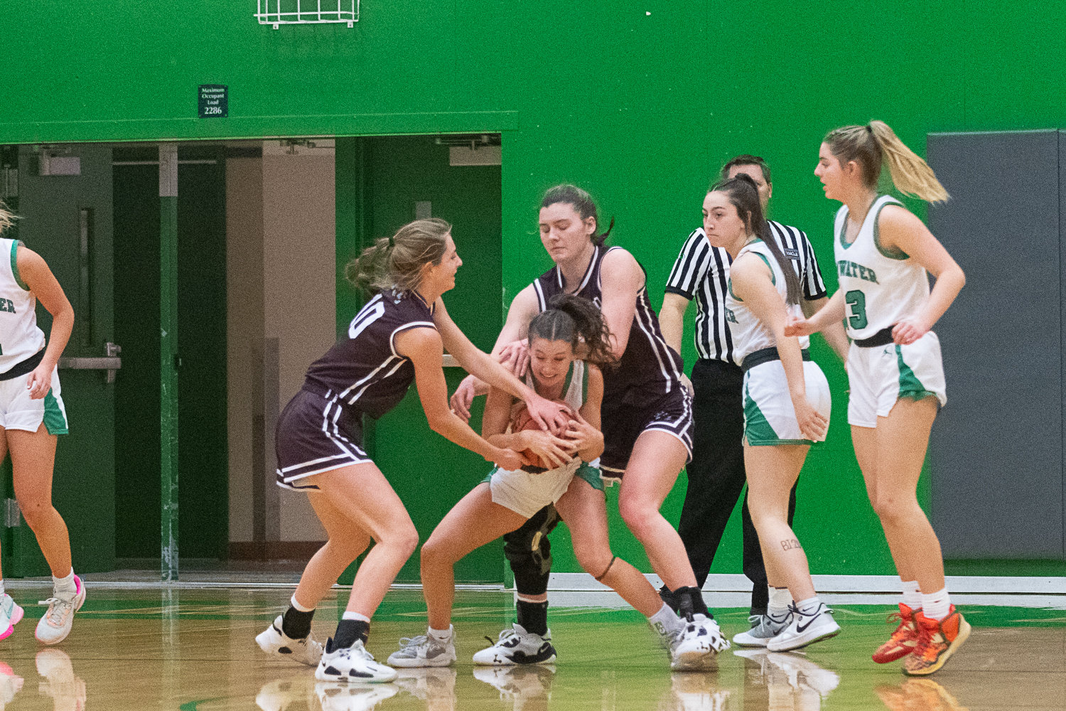 Regan Brewer tries to fight off two Montesano players for possession during the second half of Tumwater's 37-21 loss to the Bulldogs on Dec. 22.