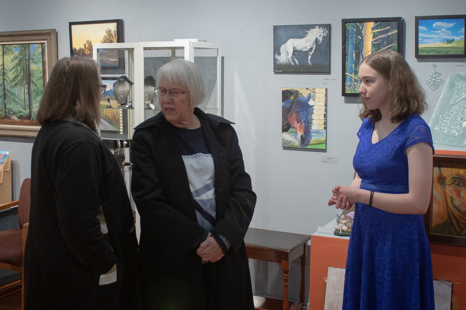 Home-schooled freshman Coral Earrame talks to gallery visitors during the emerging artist gala Friday night at the Rectangle Gallery & Creative Space.