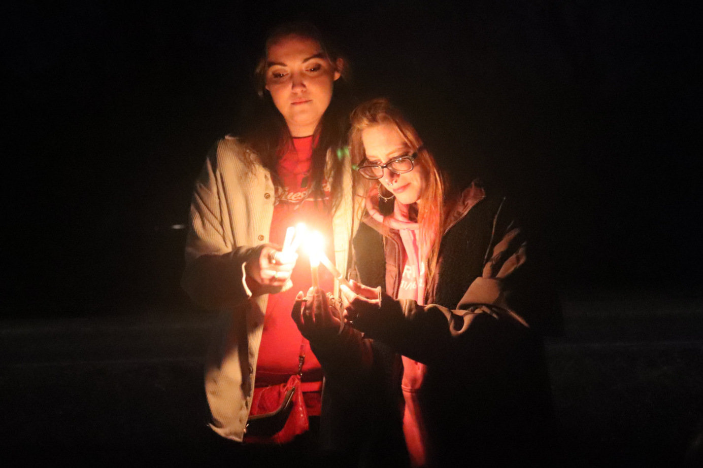 Sisters Karlee and Taylor Bodine share a tender moment at a vigil held in January  2021, on the 15th anniversary of the day their mother’s body was found on the side of Littlerock Road Southwest near Rochester.