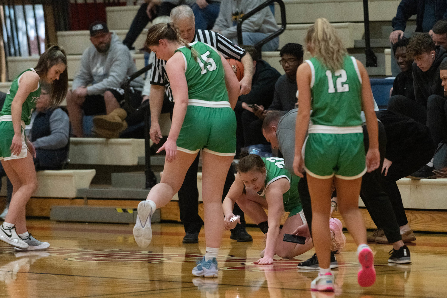 The Thunderbirds team up to look for a lost contact lens during the first quarter of the T-Birds' 39-25 win over Kelso on Jan. 16 at the LCC MLK Day Classic in Longview.
