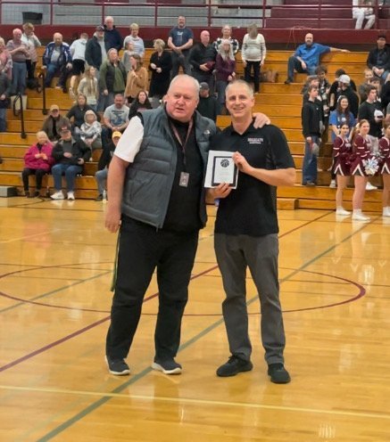 W.F. West athletic director Jeff Johnson presents head basketball coach Chris White with a plaque commemorating his 100th career win, before the Bearcats' 50-47 win over Shelton on Jan. 17