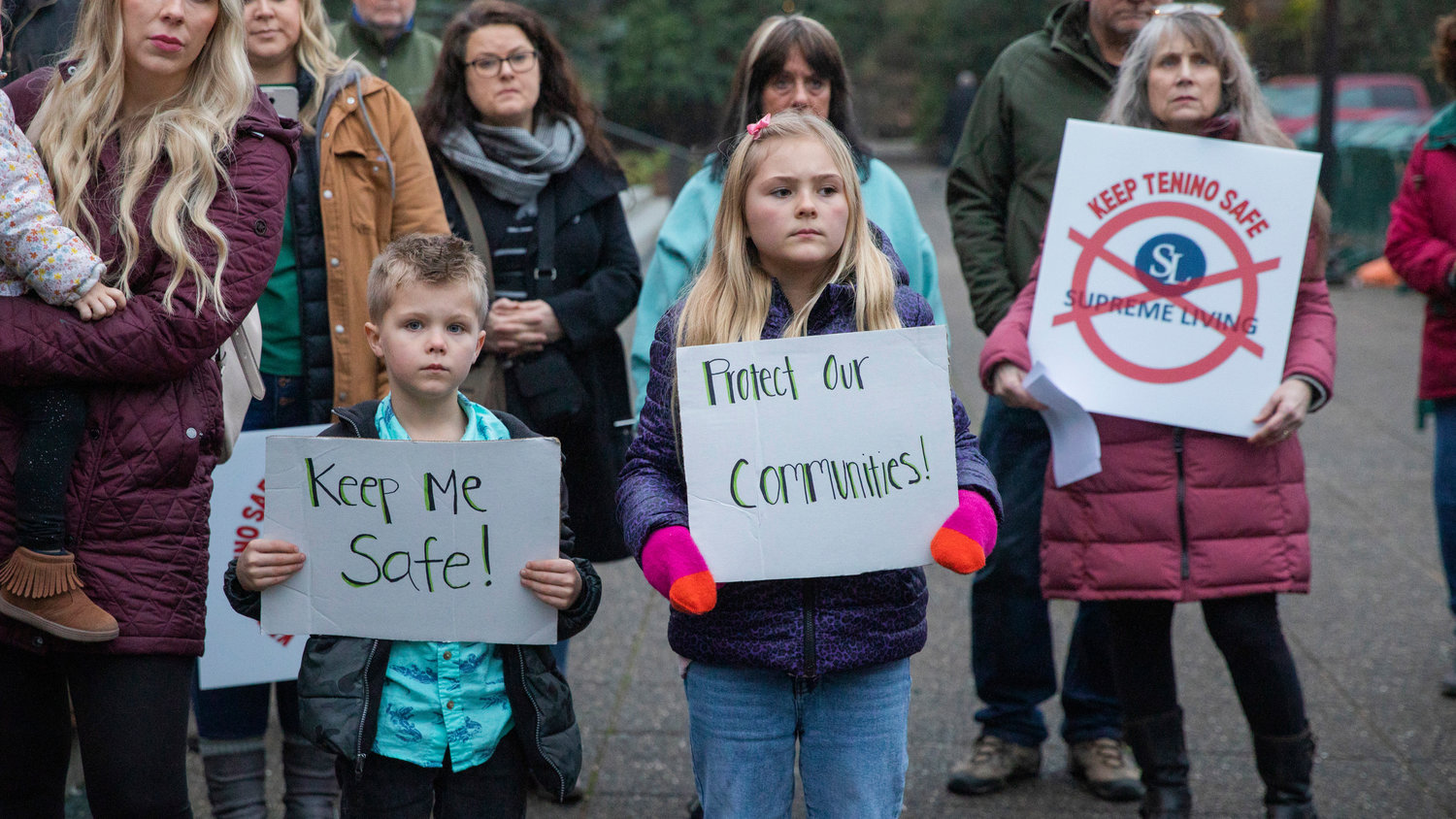 Kids hold signs while standing with Tenino residents against Supreme Living outside the Washington State Capitol Building in Olympia on Thursday.