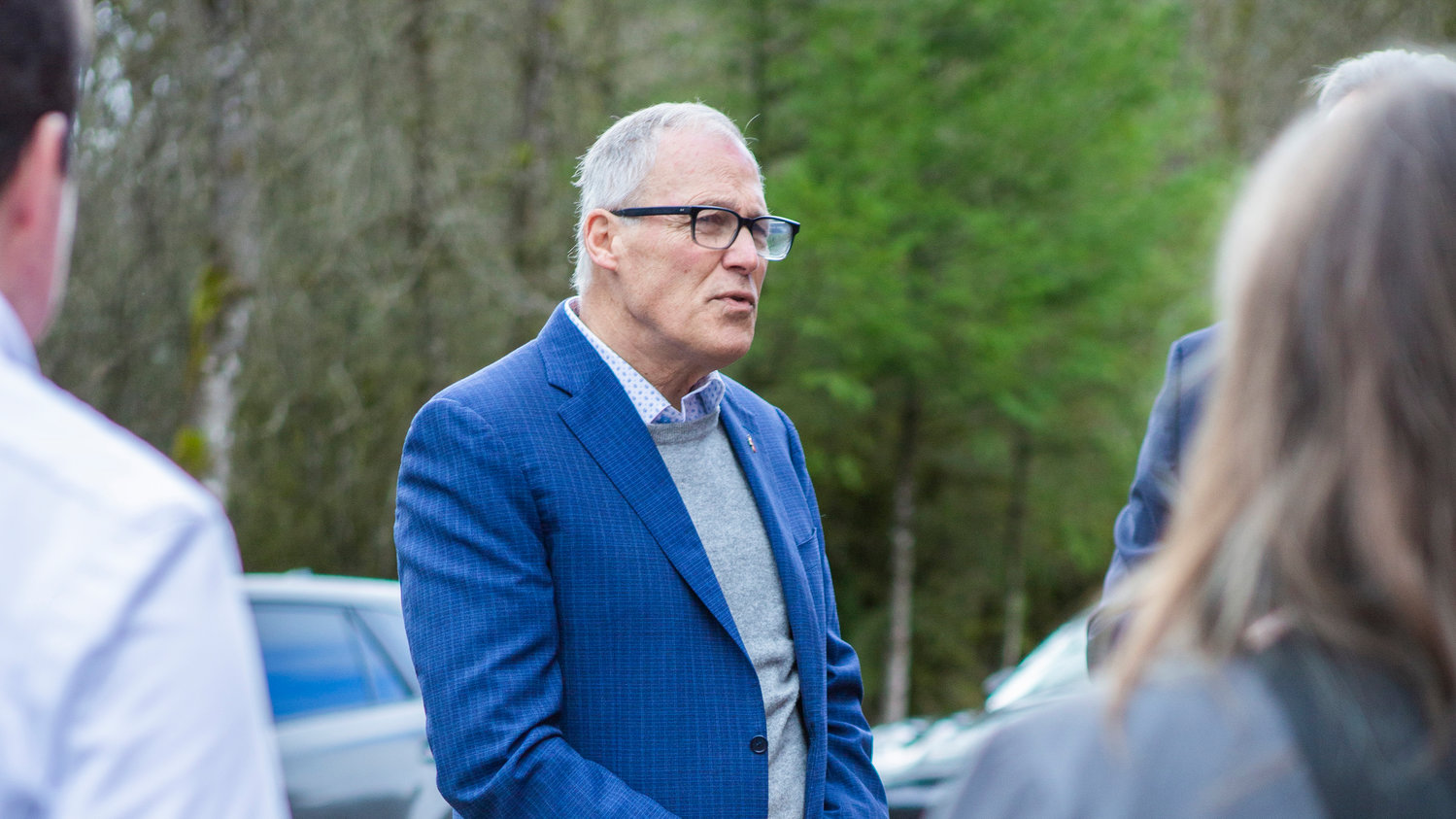 Gov. Jay Inslee speaks with his staff during an event northwest of Centralia on Friday, Jan. 27.