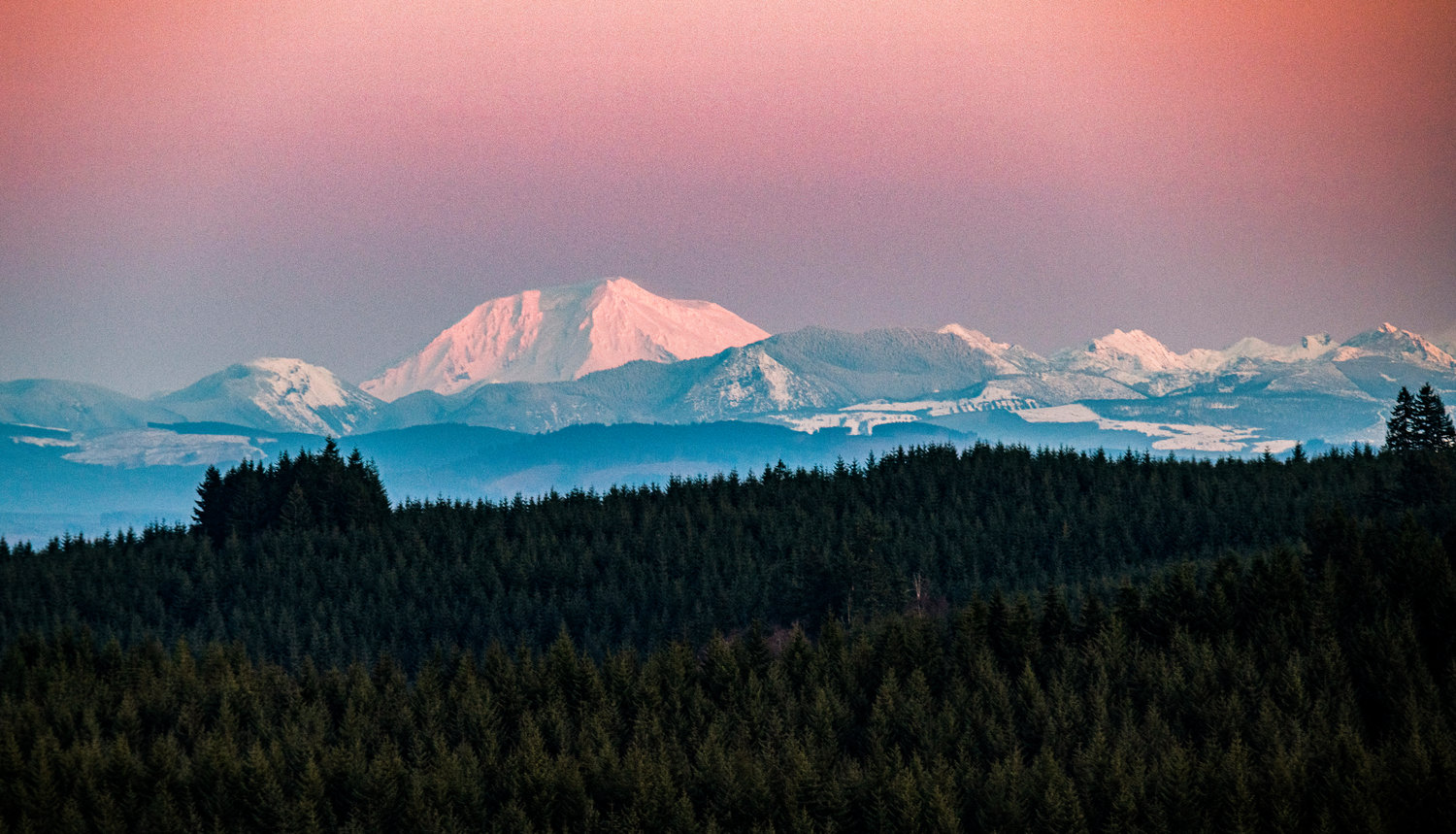 From Crego Hill on Sunday night, Mount Adams glows as the sunset casts pink and orange on foothills beside it.